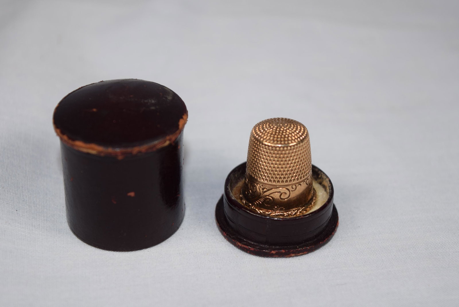 Gold Thimble in Original Case: This nice gold thimble comes in original case. Marked with a 10 on the outside. Gold tested 14K. Beautifully engraved. Marked with some initials on the inside. Great overall condition with no damage o