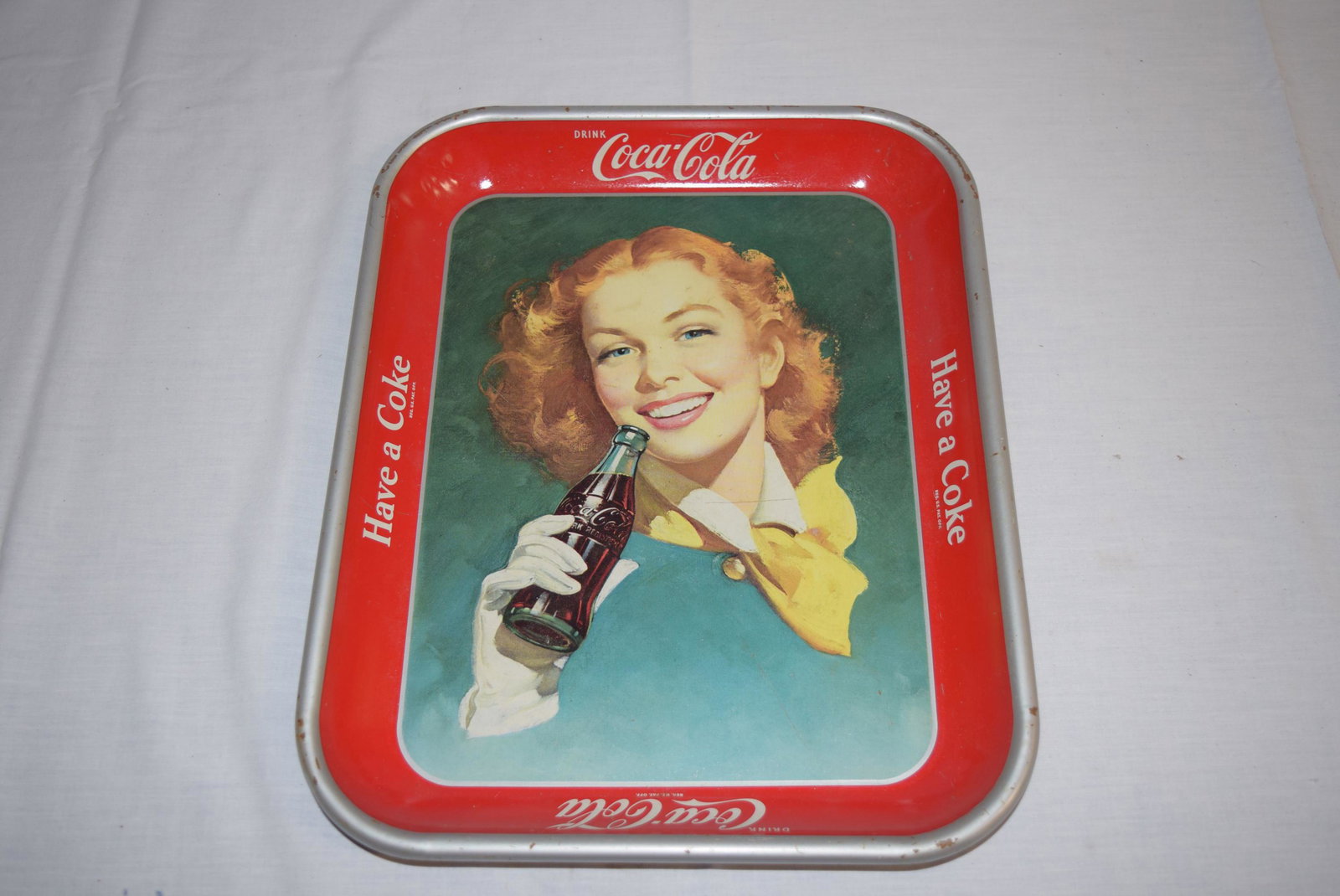 1950's Coca-Cola AD Tray: This nice AD tray features a women holding a Coca-Cola in her hand and has a read border reading Have A Coke and Coca-Cola. This measures 13.25in x 10.75in overall. Some minor scuffs around the top ed