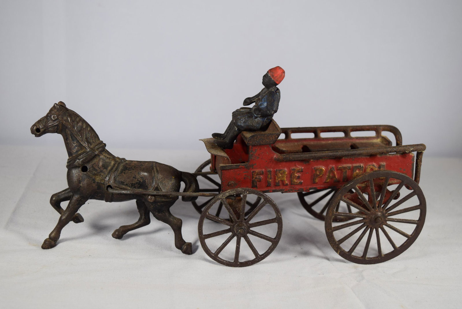 Vintage Cast Iron Fire Patrol Toy: This nice vintage toy features a horse pulling a Fire Patrol Wagon. This include the driver. Embossed Fire Patrol on both sides of the wagon. Appears that the man is missing his reins for the horse. O