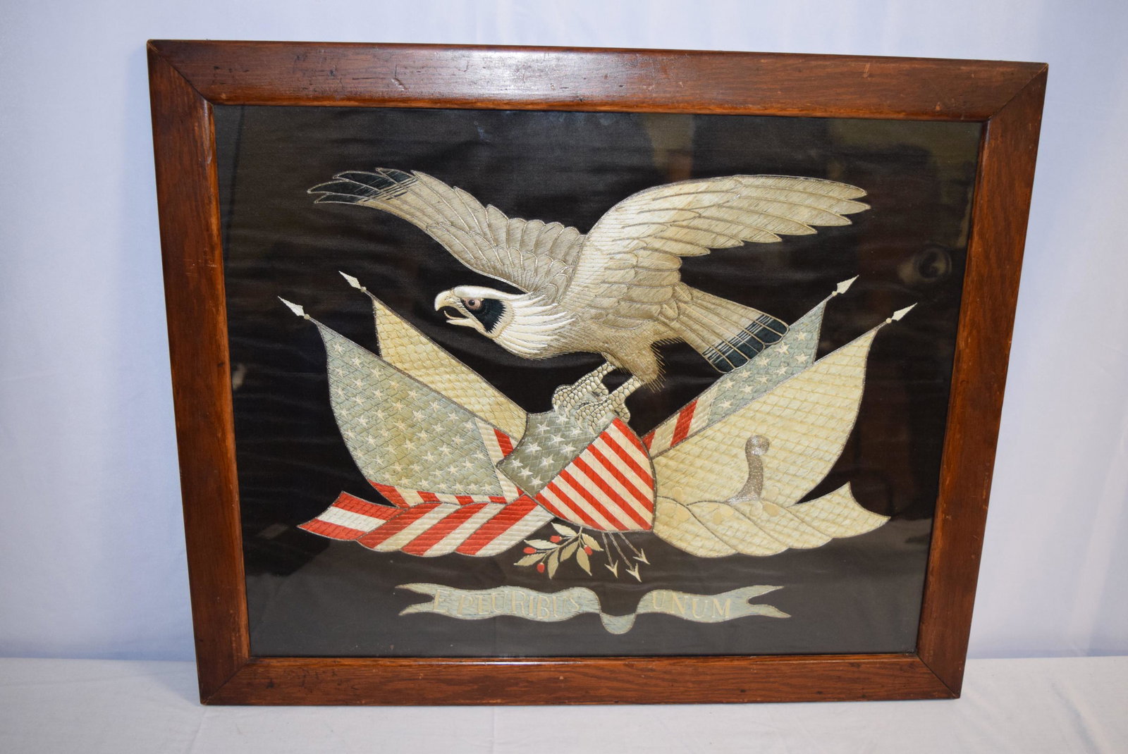 Silk Embroidery Eagle With Shield, Arrows and Branch: This beautiful framed piece feature a bald eagle holding a shield with the American flag, three arrows and branch with leaves and berries on it. This appears to have silk thread and is on silk as well