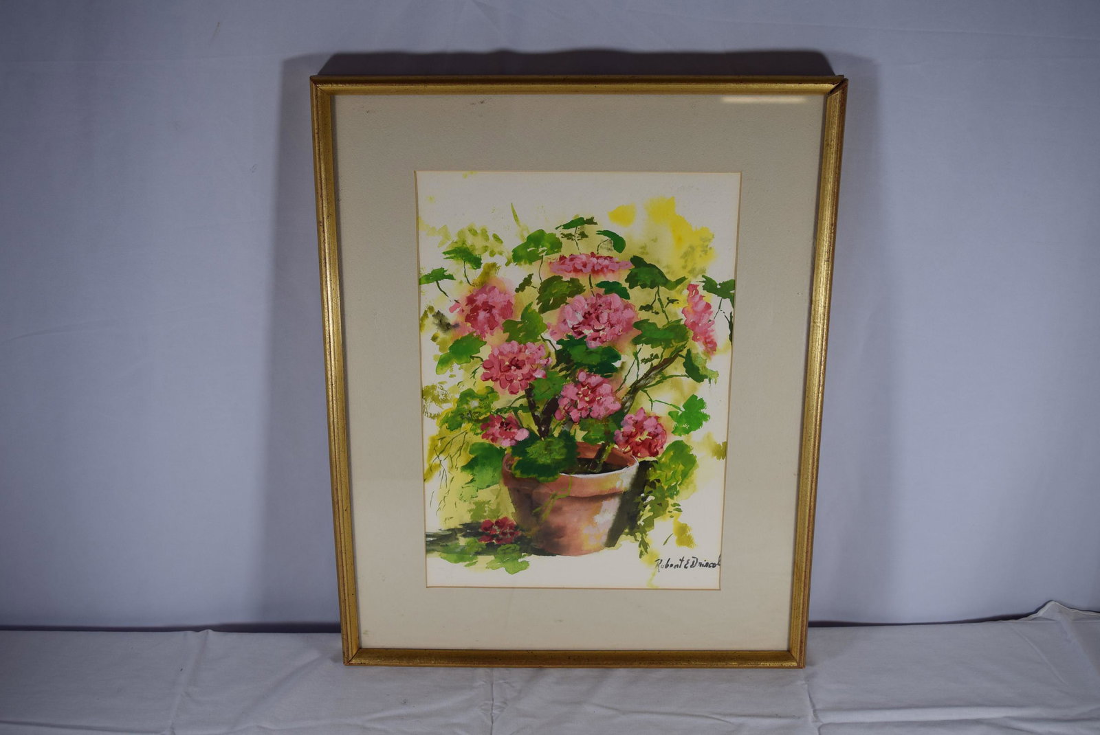 Watercolor Signed Robert E Driscoll: This beautiful watercolor is on paper and signed by listed Cape Cod artist Robert E Driscoll. This is titled Bouquet we believe. Features a pink geranium in a pot. This measures in frame 17in W x 20.5