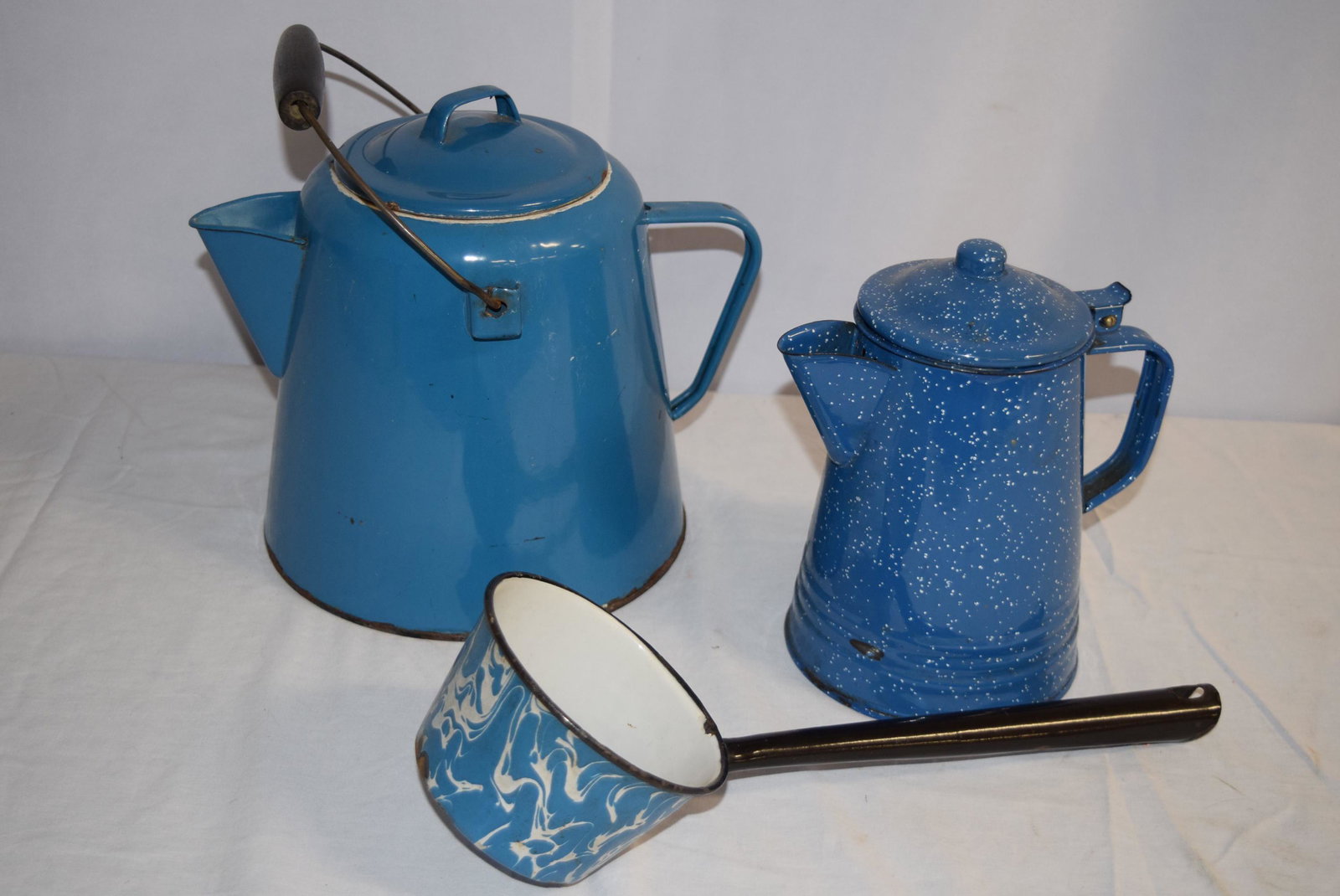 Vintage Lot of Enamel Ware: This lot includes vintage blue enamel kettle with bale handle that measures approx. 9in T including cover however not including bale handle. Some rust on the inner edge of the cover and around the bot