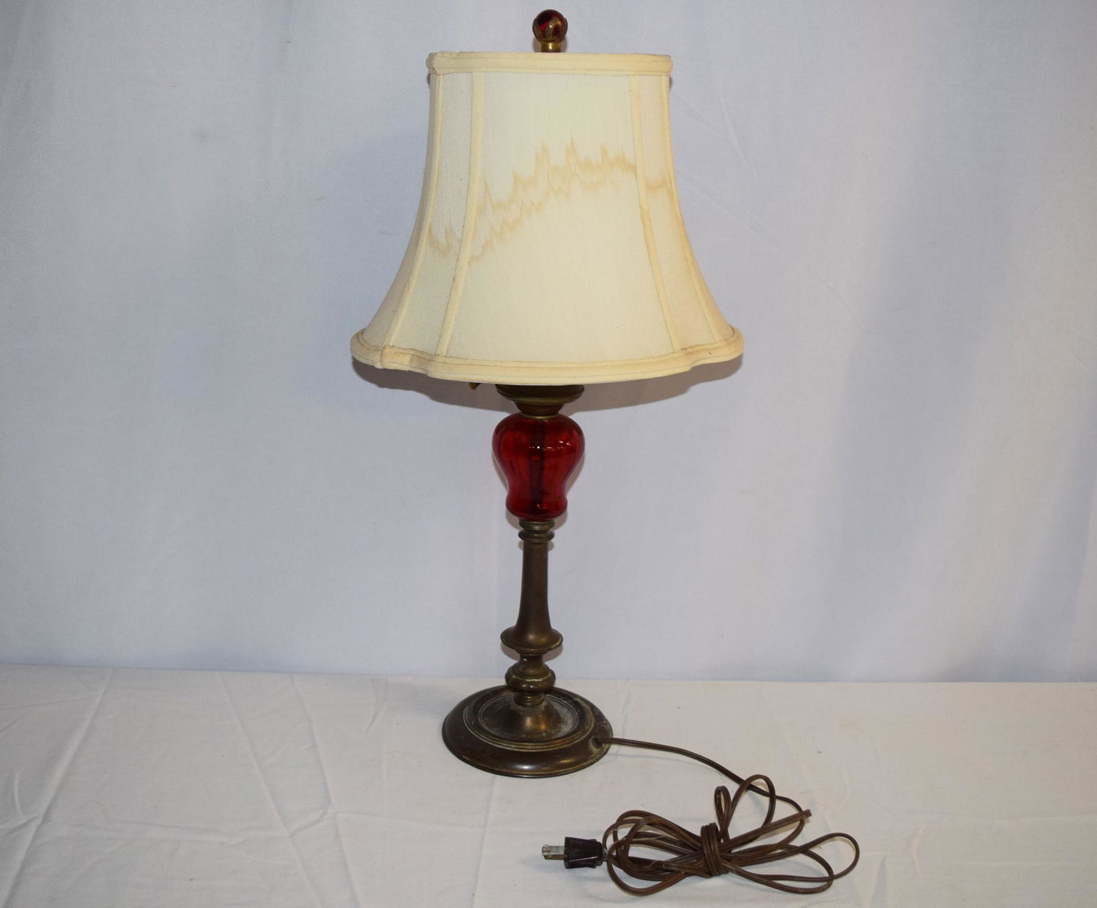 Vintage Mutual Sunset Lamp Co. Table Lamp: Vintage Mutual Sunset Lamp Co. table lamp is brass with a pop of red glass in the center for decoration. Embossed on bottom MSLC. 4468. The red glass has a chip and crack about 3in L as photos show. T
