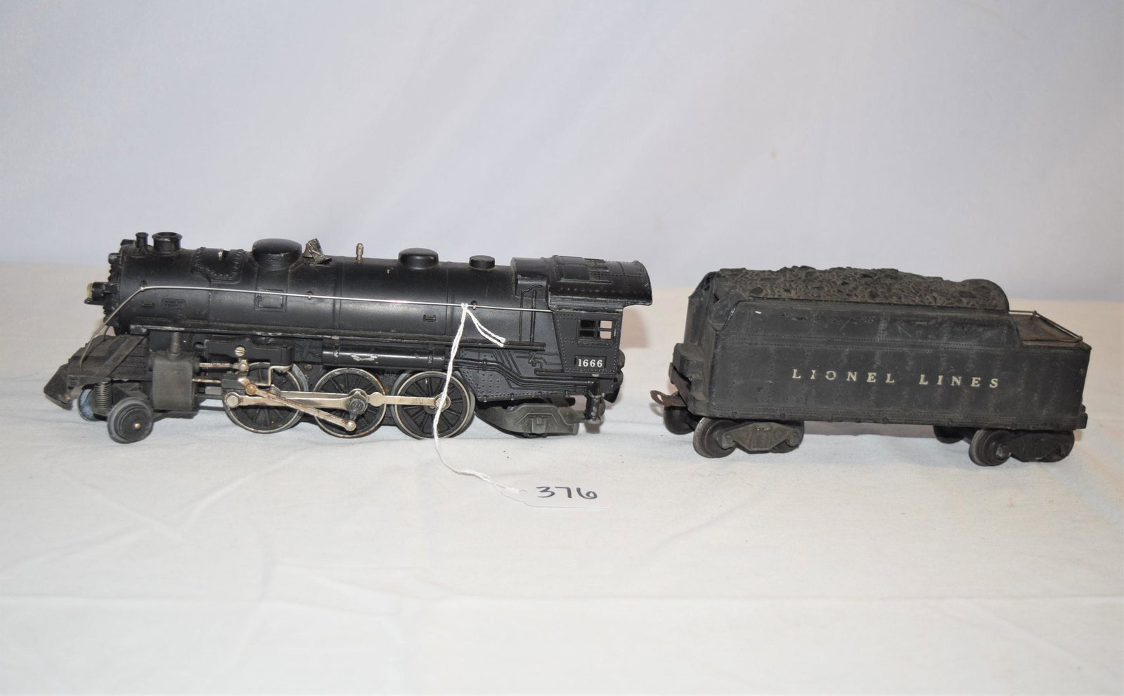 Vintage Lionel Lines 1666 Engine and Coal Tender: Lot includes Lionel Lines 1666 engine with 6466W coal tender. Normal handling ware and paint loss. The bell on top is bent slightly. Very slight rust. Overall these appear to be in good condition. We 