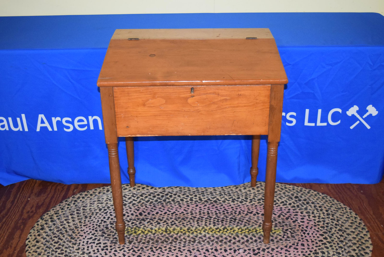 Early American Pine Schoolmasters Desk: Early American pine school masters desk. Features turn legs and small interior with dovetail drawer. Measures 32.75in T x 28in W x 21.75in D overall. Sliver of wood off top and overall normal handling