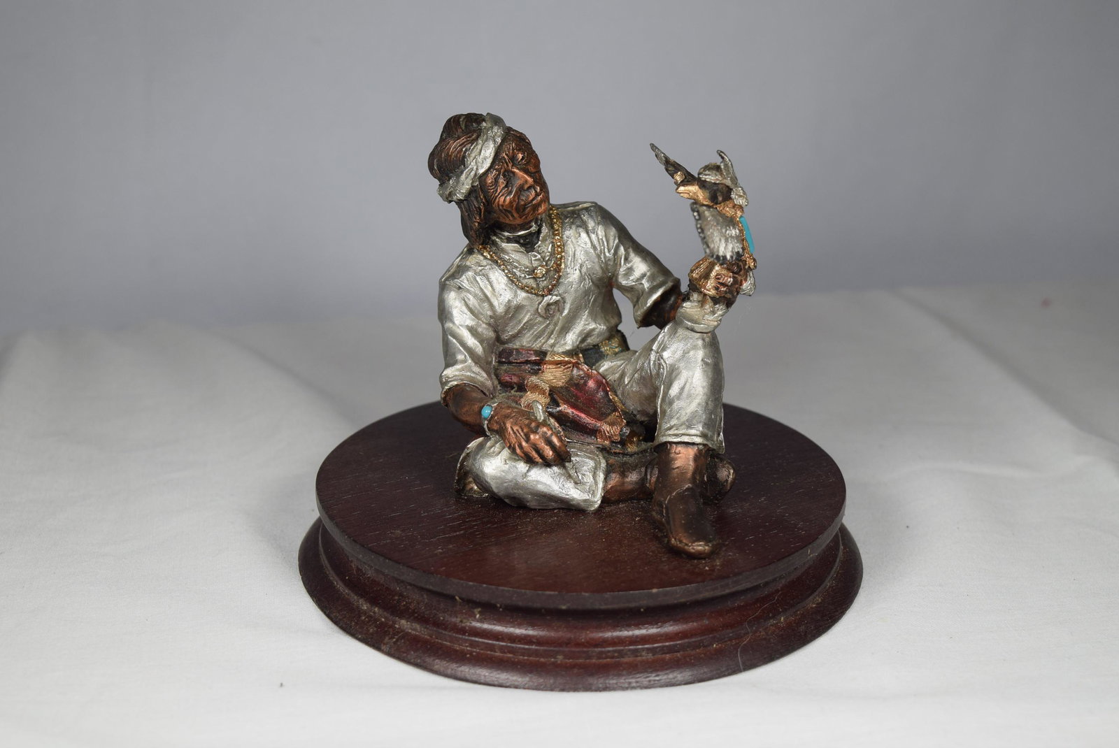 Limited Edition 1990 Legends Figural Statue: Limited edition Legends mixed media Kachina Carver 1990 figural statue featuring an Indian man sitting down holding a statue of man in an eagle mask and wings. Statue is signed C. A. Padell, numbered