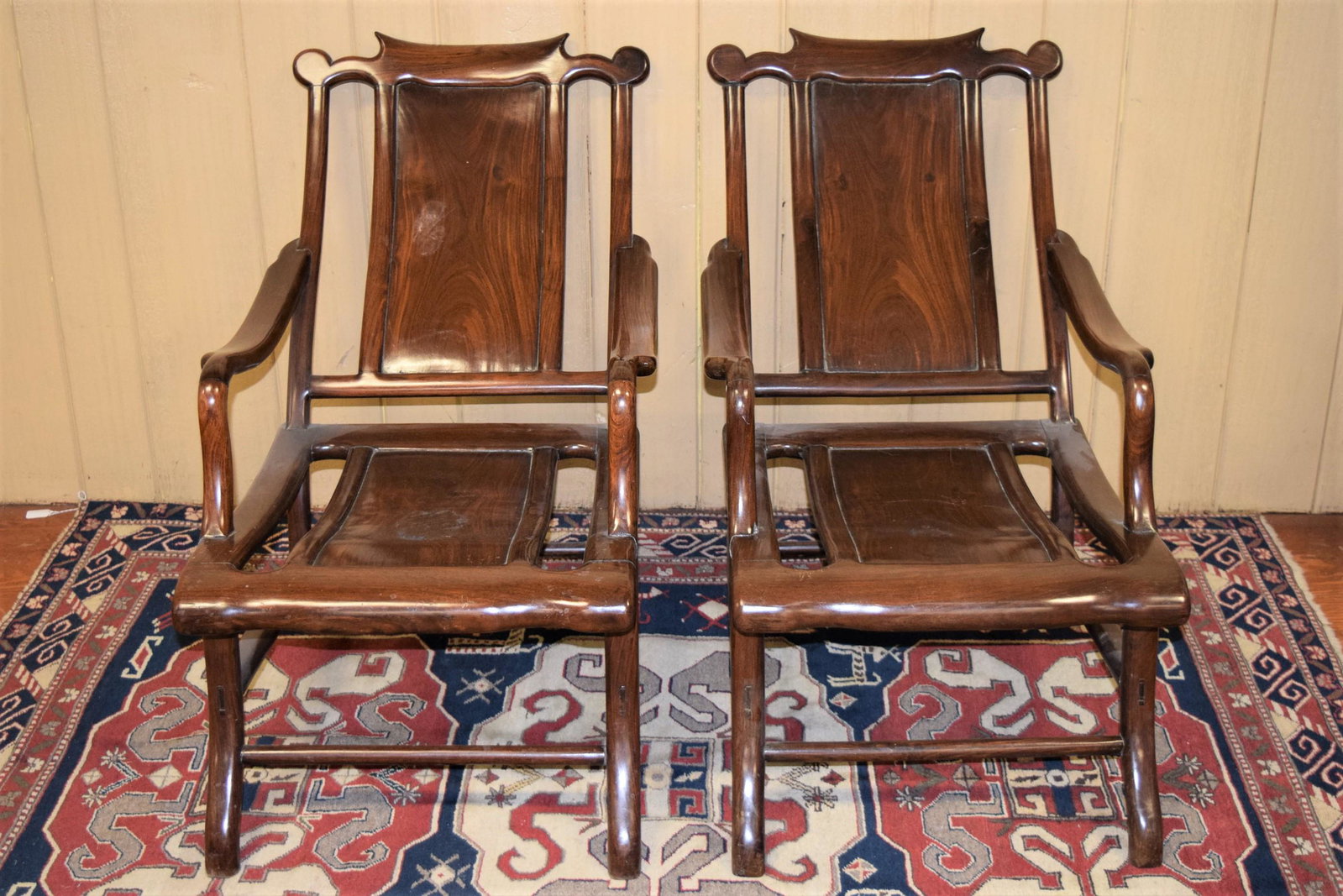 Pair of Turn of the Century Rosewood Lounge Chairs: Pair of Turn of the Century Rosewood Reclined Lounge Chairs. This beautiful set of chairs are the ideal set to put in your living room for full relaxation as you take in their all wood smooth finish. 