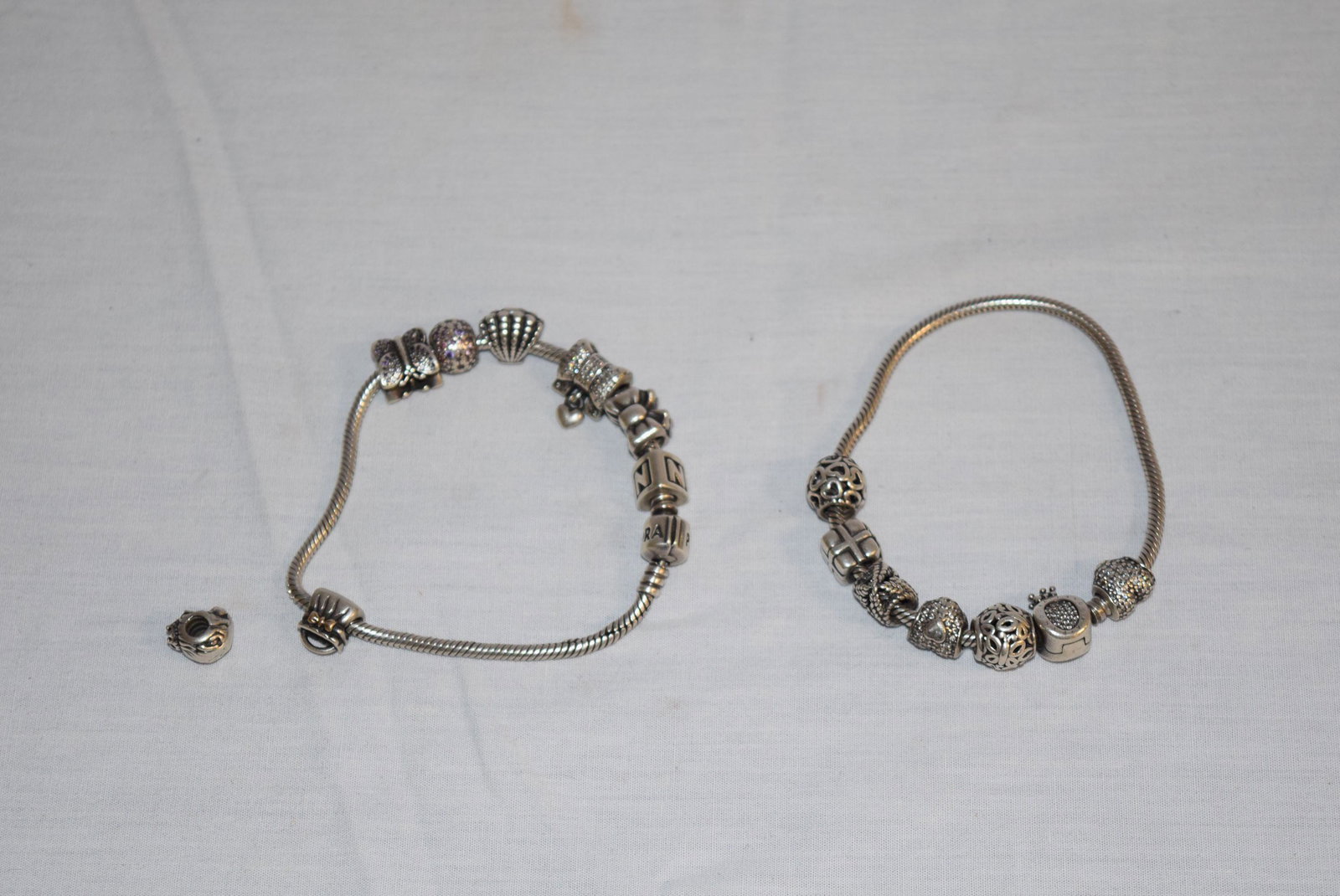 Lot of Two Pandora Charm Bracelets: Lot of Two Pandora Charm Bracelets features a rope bracelet with several charms on both bracelets! Excellent lot to add to your jewelry collection or give one as a gift to have matching bracelets; per