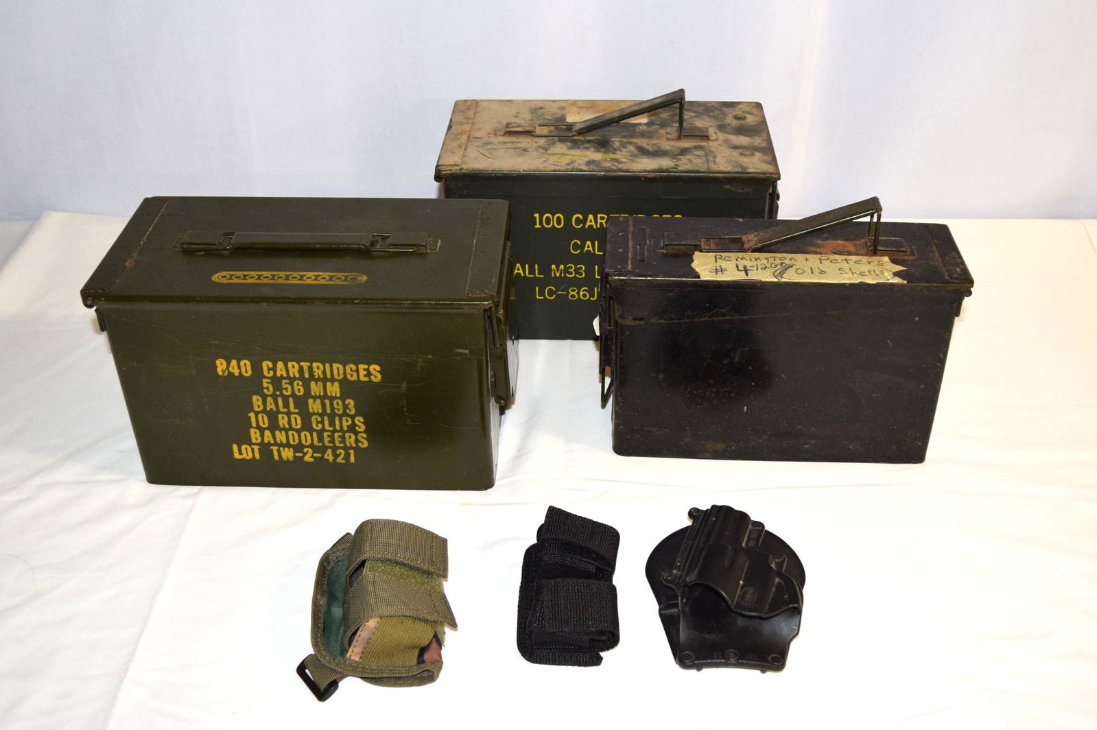Large Ammo Lot with Military Ammo Boxes: Large Ammo Lot with Military Ammo Boxes includes a military ammo box full of Remington Peters 12GA #4 Old Ammo, 3 Holsters, 4 HKS Revolver Speedloader, Box of 50 rounds of .45 Auto, Box of 20 Rounds o