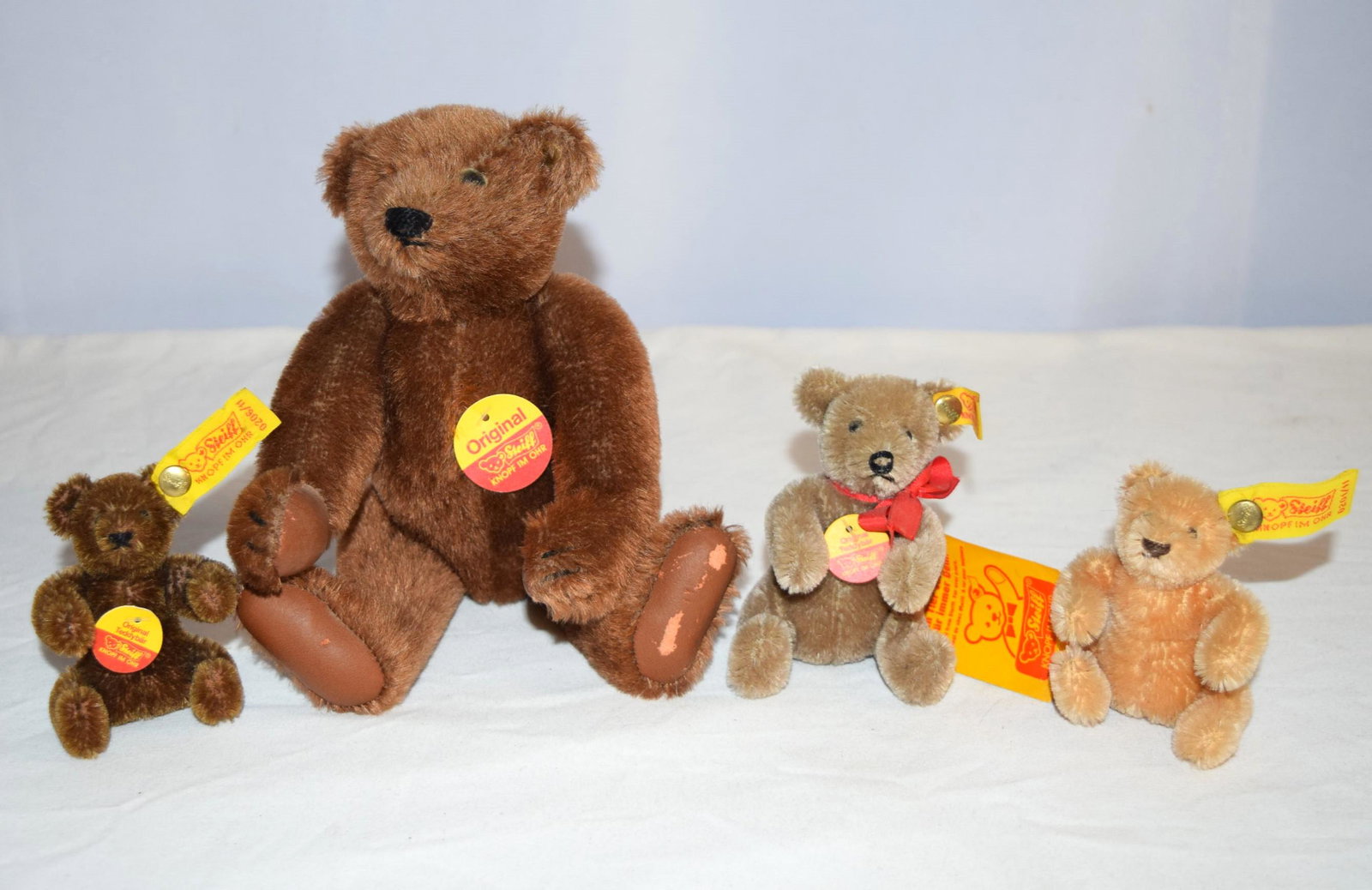 Lot of Four Steiff Original Teddy Bears: Lot of Four Steiff Original Teddy Bears. The largest bear is brown, 5-Way Jointed, with Chest ID Tag, Leather Paw Pads and Stitched Nose and Mouth, measuring about 8.75 inches tall. The tan bear is no