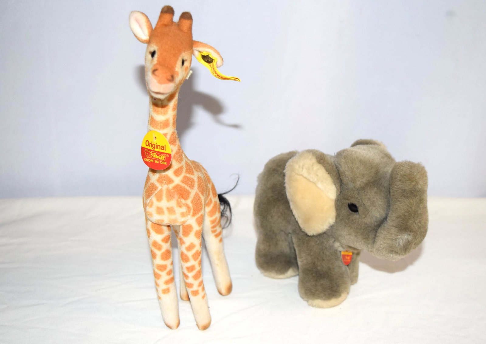 Lot of Two Original Steiff Animals with ID Tags: Lot of Two Original Steiff Animals with ID Tags includes a Original Steiff Giraffe and Cosy Jumbo Elephant. Both Steiff animals have their Chest ID Tag and Button with Ear Tag still intact. Giraffe me