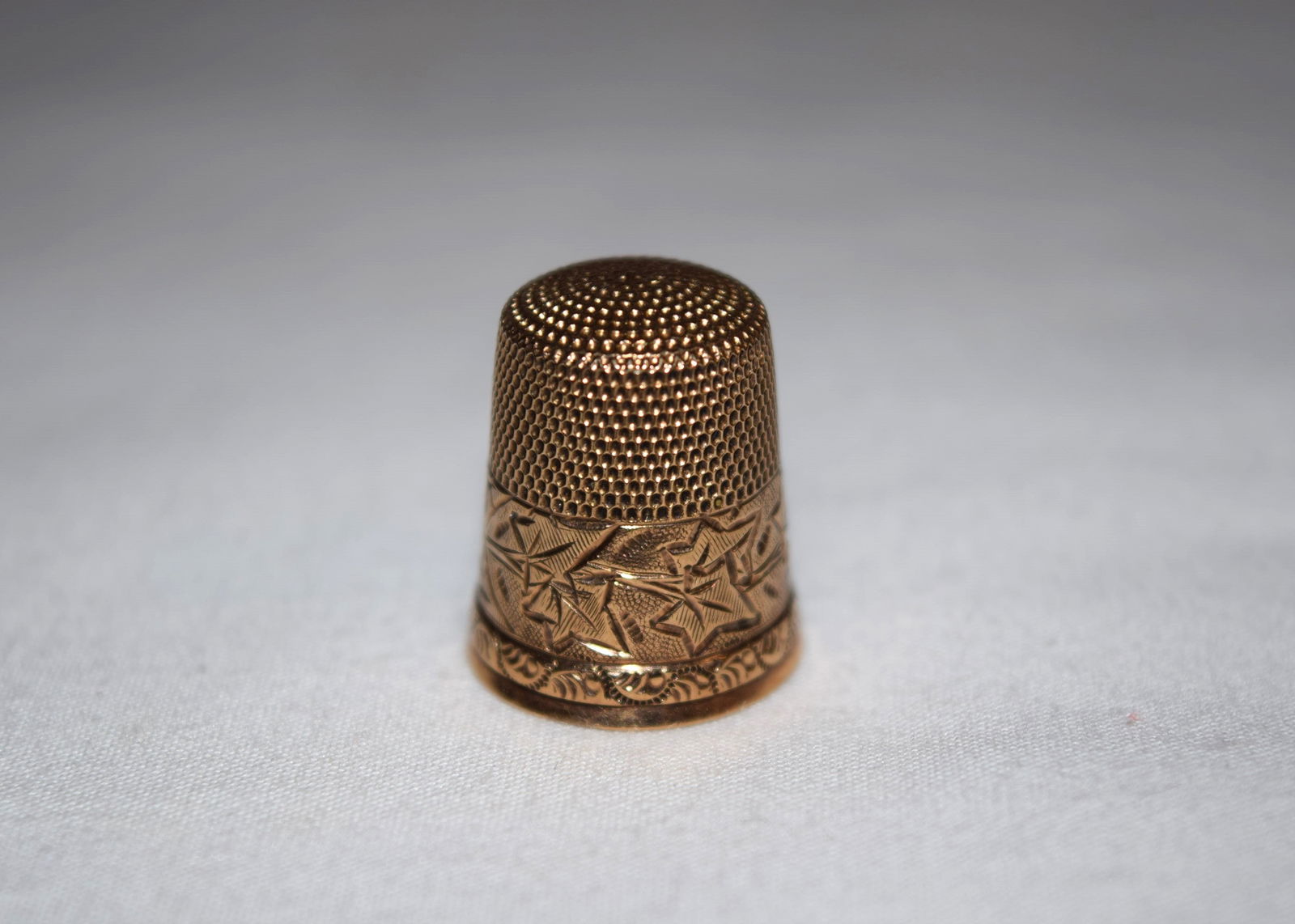 10K Yellow Gold Engraved Leaf Rim Thimble: 10K Yellow Gold Engraved Leaf Rim Thimble weighs approximately 3.5 grams. Is marked 10K however it acid tested 14K. All items are looked over but not inspected further than with the naked eye. If you