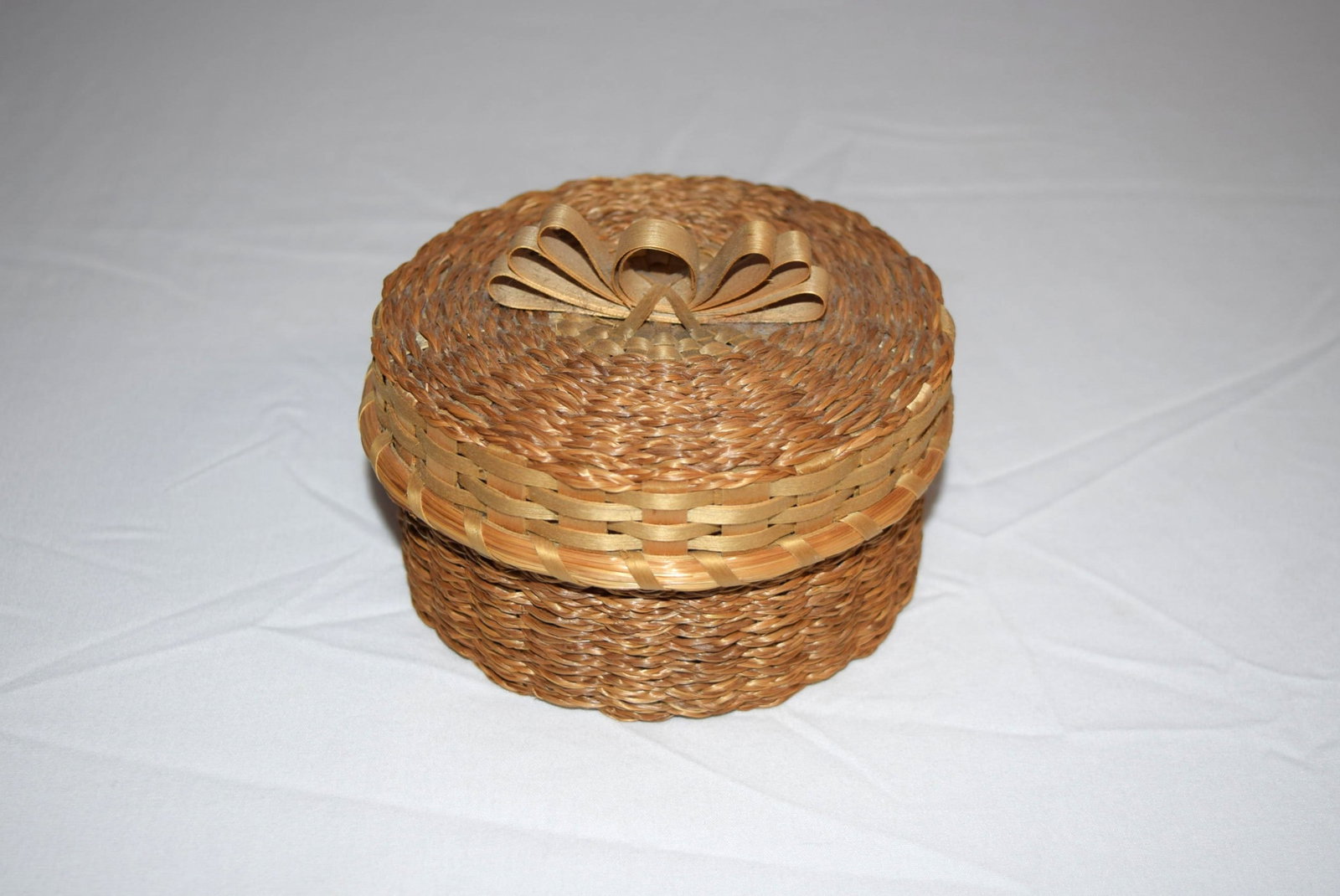 Passamaquoddy Handmade Indian Basket: Passamaquoddy Handmade Indian Basket comprised of ash and sweetgrass, measuring approximately 4.25 inches round X 2.5 inches tall X 4.5 inches round on top. Signed on bottom by Basketmaker. Appears to