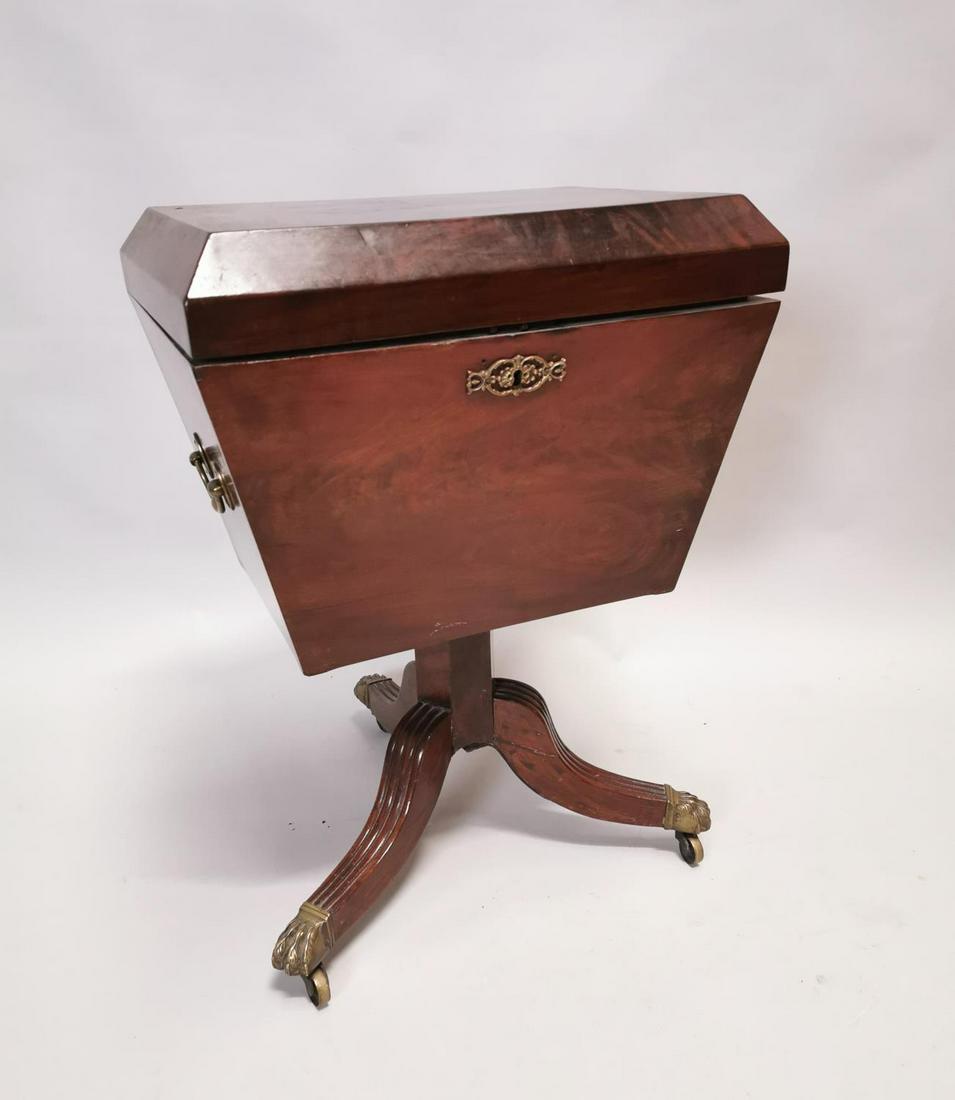 Georgian mahogany wine cooler.: Georgian mahogany wine cooler raised on single column, three outswept legs on brass lion paw feet castors {65 cm H x 46 cm W x 34 cm D}.