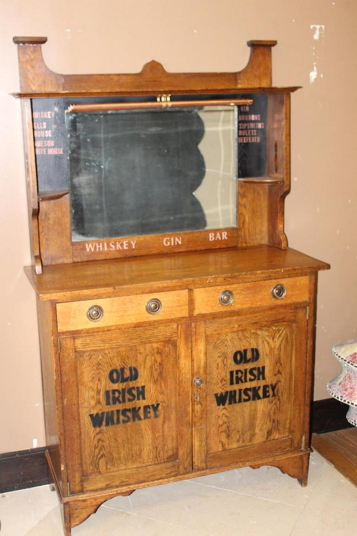 Oak home bar.: Oak home bar with mirrored back, brass glass holder and two drawers over two doors {180 cm H x 107 cm W x 43 cm D}.