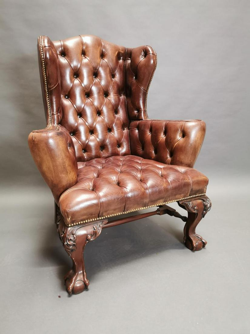 Leather deep buttoned wing back arm chair.: Exceptional quality hand died leather deep buttoned wing back arm chair on carved mahogany legs {122 cm H x 95 cm W x 75 cm D}.