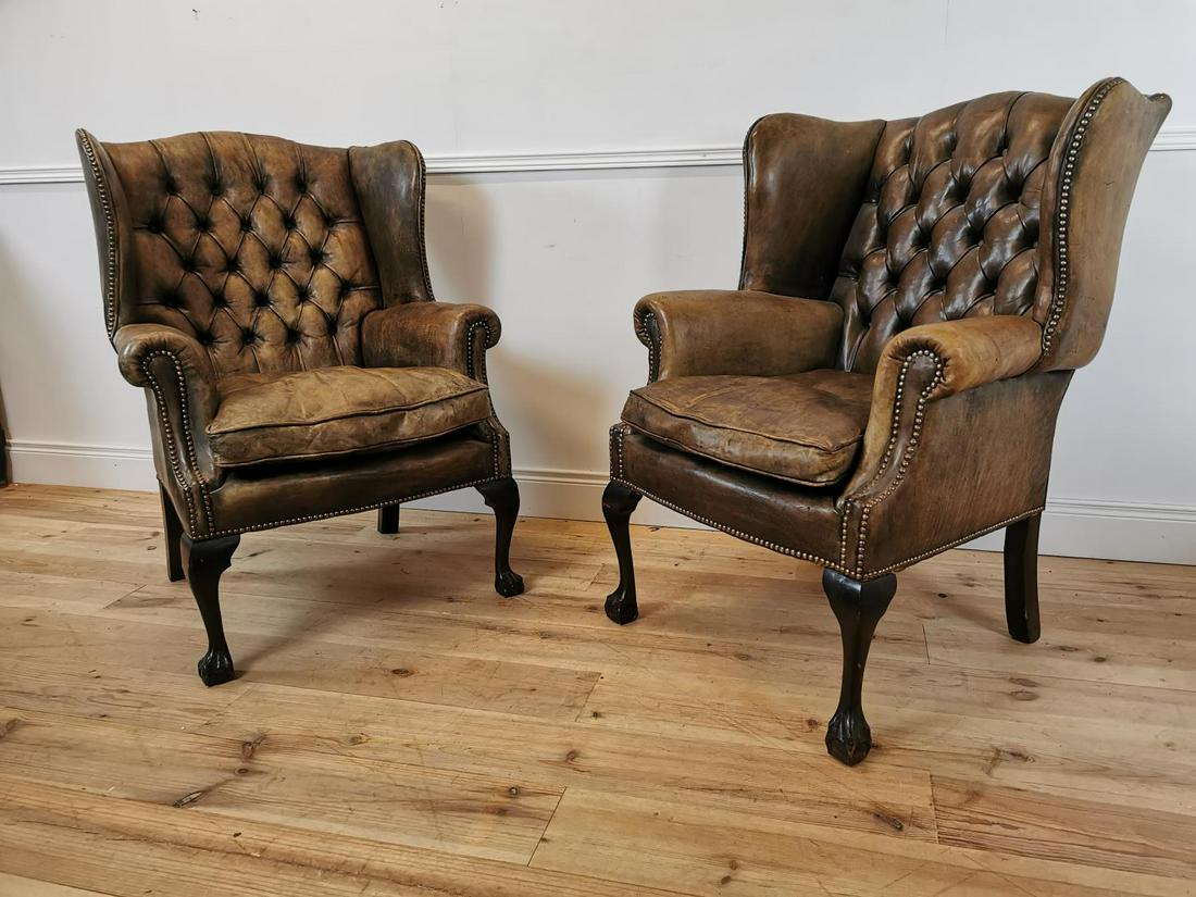 Pair of early 20th C. hand died brown leather deep: Pair of early 20th C. hand died brown leather deep buttoned wing back chairs with brass studs raised on cabriole legs and ball and claw feet {103 cm H x 77 cm W x 80 cm D}.