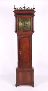 An English Tall Case Clock by John Lawson of Newton: A Regency Period example with an oak case which features crossbanded lower panel and door, fluted quarter columns, and a bonnet with fluted pilasters, eglomise panel, scroll work, and turned finials.