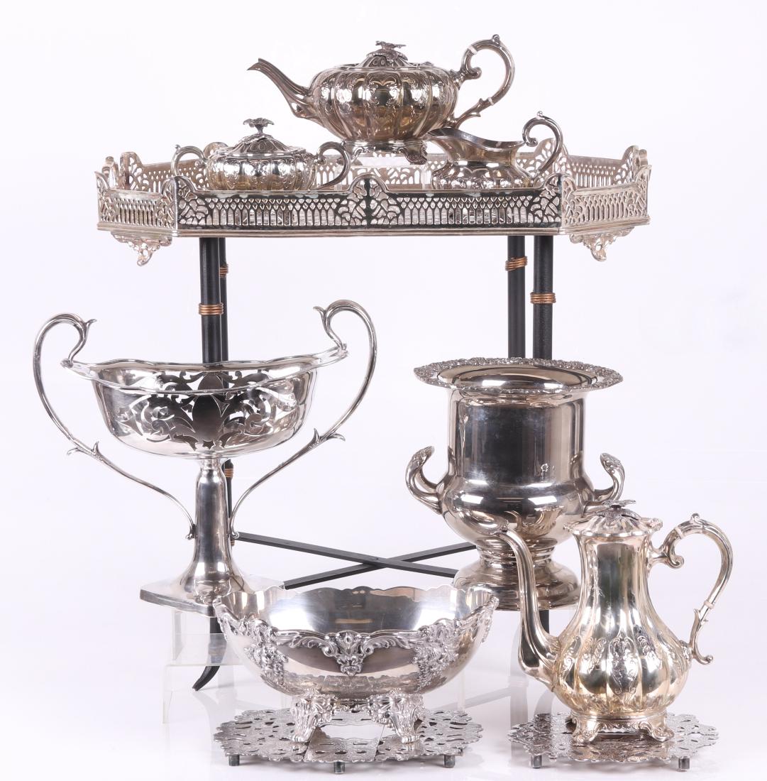 Silver Plated Hollowware and a Tray with Stand: All from the first half of the 20th century, comprising: a Regency style wine cooler, a four piece lobed and engraved tea set marked "Made in Sheffield England, a Reed and Barton serving bowl in the K