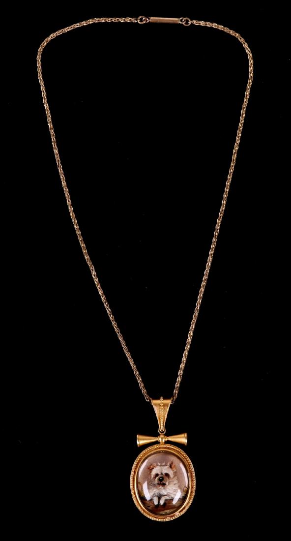 A Victorian 22k Gold Dog Themed Pendant: A reverse painted intaglio rock crystal 19th century pendant, signed "J.B.". With artwork depicting a terrier breed dog. Set in 22k yellow gold with mother of pearl backing. The chain is later and cos