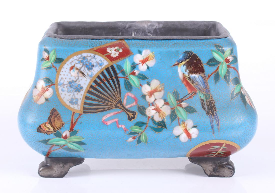 A 19th Century Porcelain Jardiniere c. 1880: With scrolled feet, a blue ground with Japanese inspired hand painted decoration that includes birds and flowers. The liner is lead. Dimensions: 11 1/2" x 7", 7" tall. Provenance: From a Main Line col