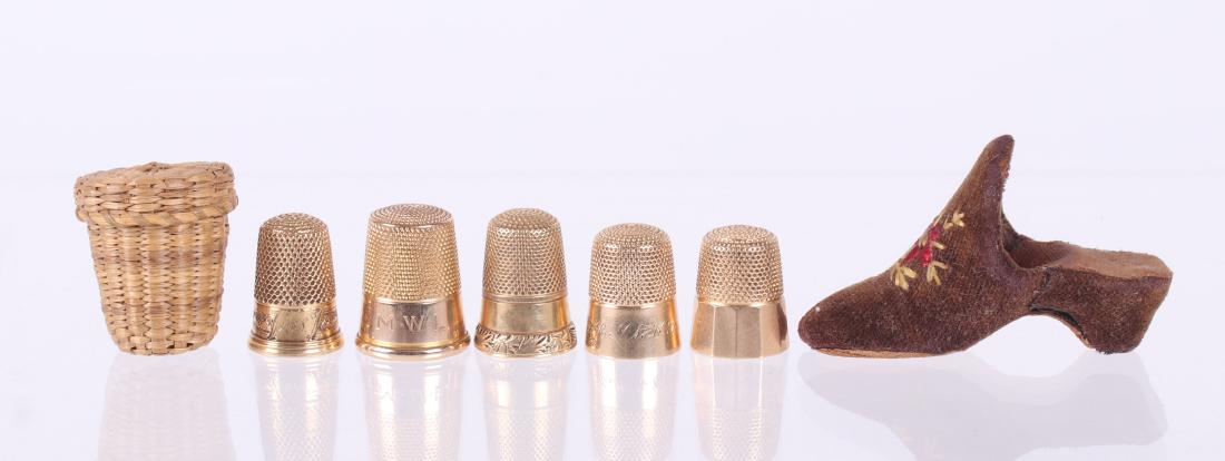 A Group of Five 14k Gold Thimbles: All either late 19th or early 20th century. Two with chased decoration; three are initialed. The lot also includes a velvet shoe form thimble holder and a woven basket form thimble holder. Dimensions:
