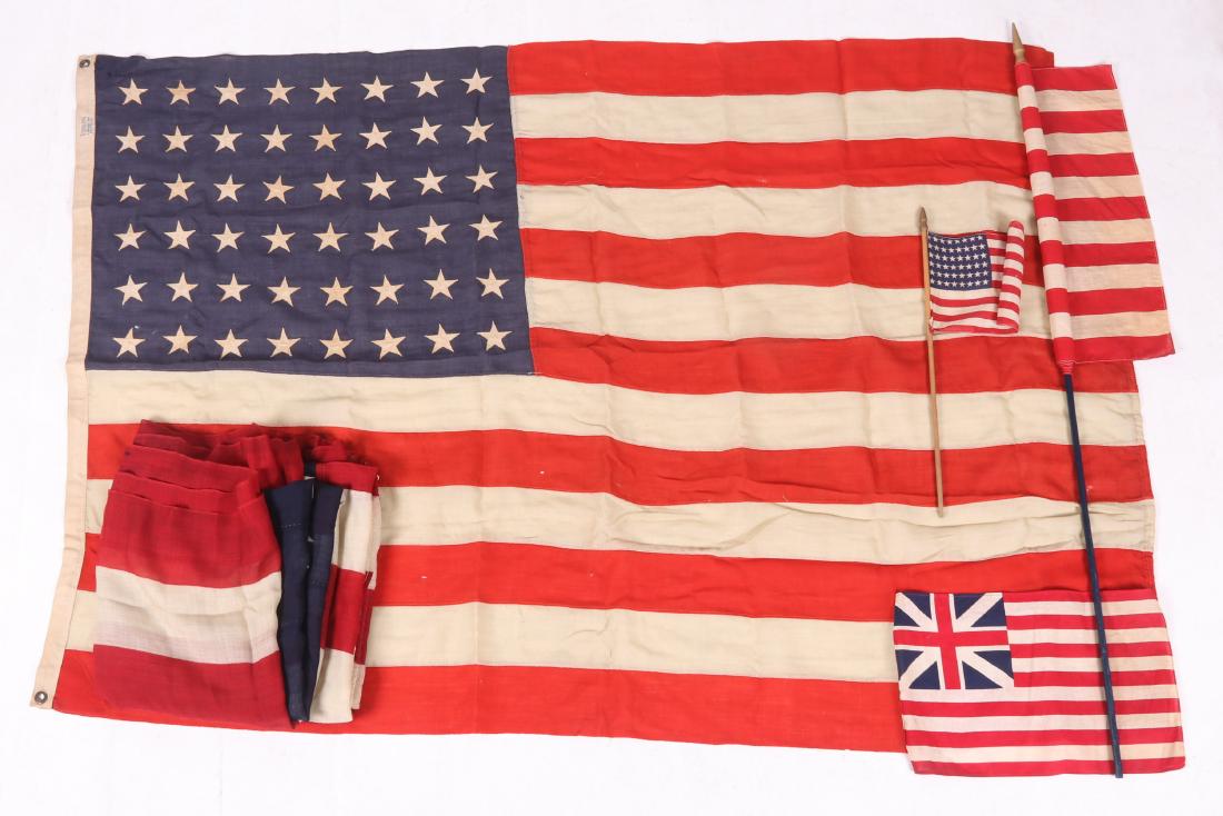 Group of Flags, US and British East India Company: Comprising: a 37 star US flag, marked "American Ensign"; three 48 star US flags of different sizes, the largest labeled Sterling; a British East India Company flag. Dimensions: From 7" x 11" to 115" x