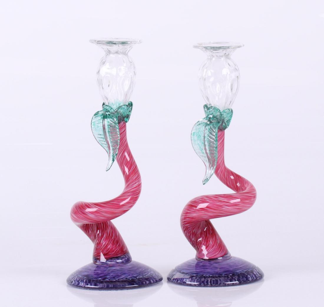 A Pair of Art Glass Candlesticks by Lewis Olson: Each with a purple circular base below a flower form shaft and nozzle. Signed and dated for 1995. Dimensions: Each is 5 1/2" in diameter and 12 1/2" tall.