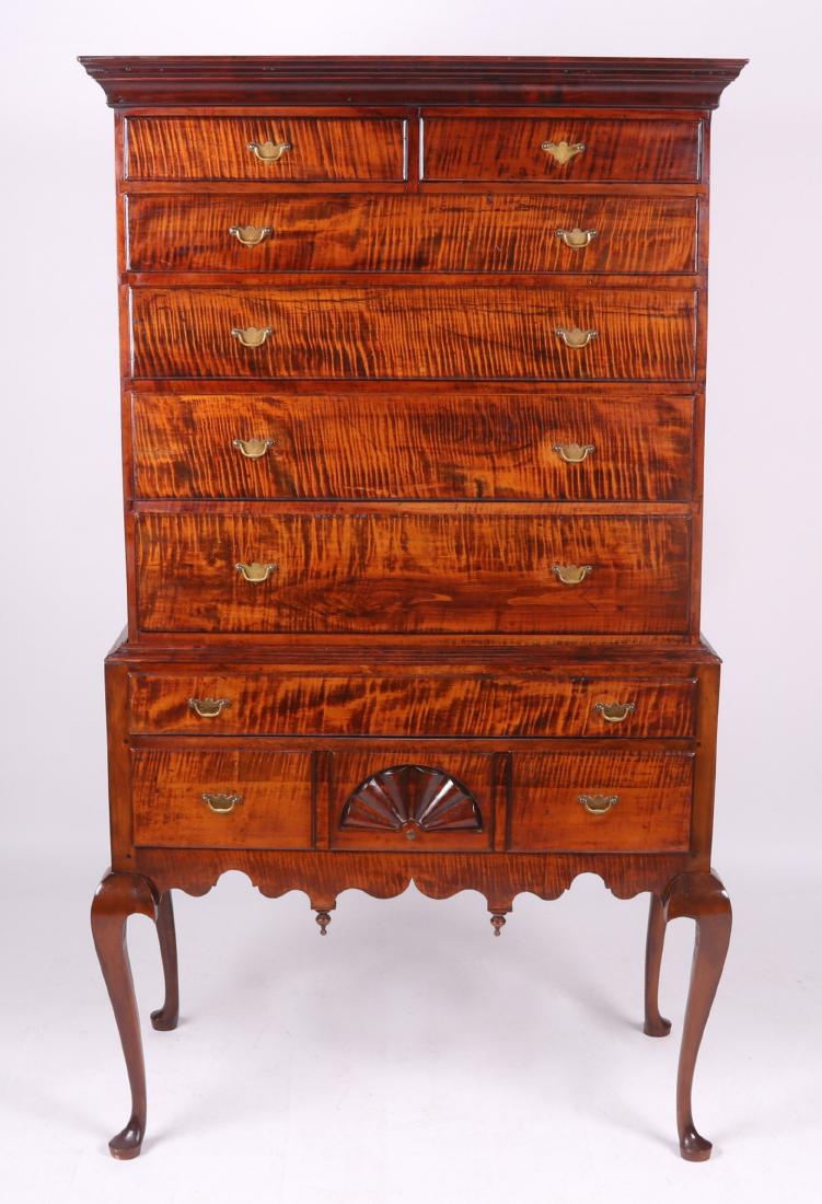 An American Queen Anne Tiger Maple Highboy: New England, chestnut and pine secondary woods. The lower case with pad foot, cabriole legs, two long drawers, the lower drawer with central fan carving. The upper case has four graduated long drawers