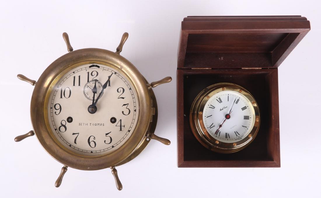 Two Nautical Clocks, Seth Thomas and Quartz: A Seth Thomas brass wheel form ship's clock, inscribed "Town River Yacht Club", Arabic numeral dial, with a key. A Quartz brass clock marked for Marc Cross, with Roman Numeral dial, mounted in a woode