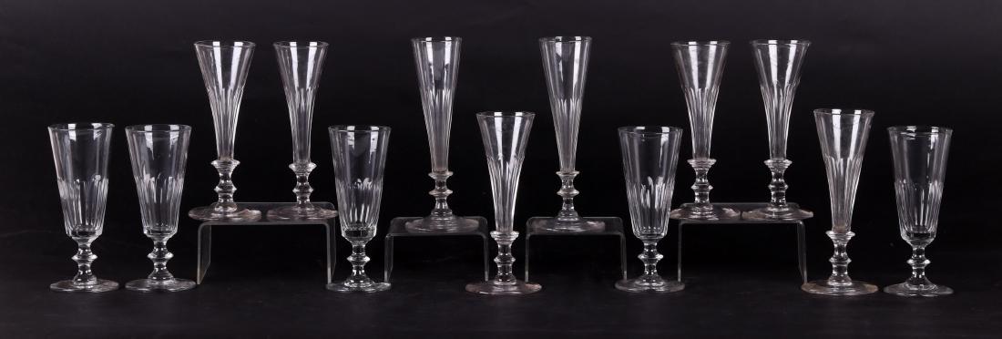 13 Early 19th Century Blown Glass Wine Glasses: All with a circular foot, knopped stem and a fluted tapered body. Dimensions: From 6 1/4" to 7 1/2" tall. Provenance: From a local estate.