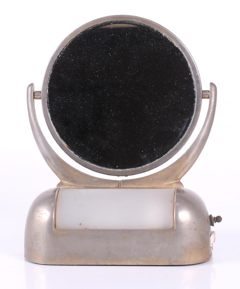 Art Deco Chrome Vanity Mirror: Acme Speciality Co., Toledo, the rotating mirror mounted to a base with a light and a lift top compartment, marked. Dimensions: 8" wide x 6" deep, 10" in height. Provenance: From a local estate.