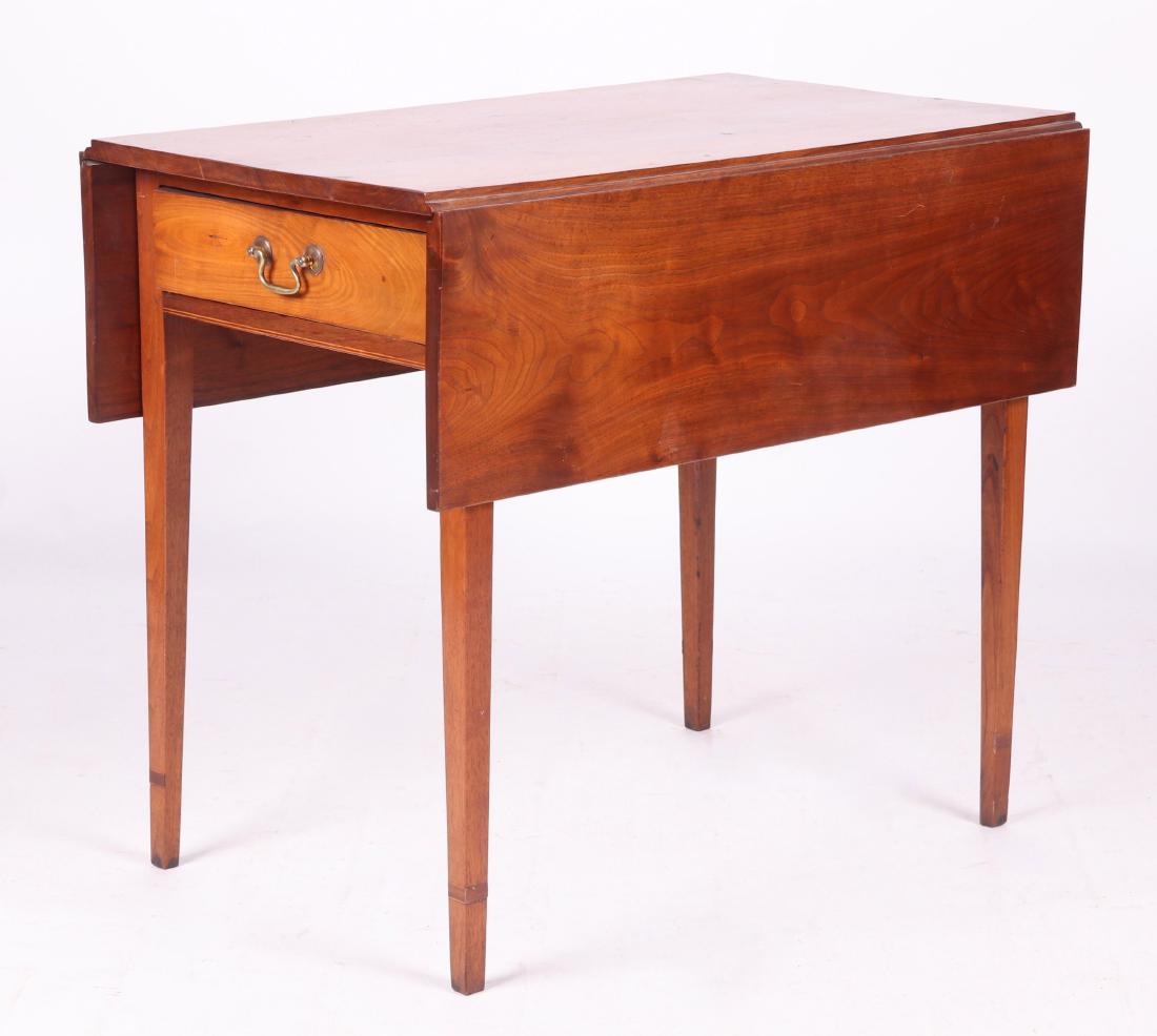 An English Mahogany Pembroke Table: Circa 1810. With square tapered legs, a single dovetailed drawer with original bail and rosette pull, and two hinged lids. Dimensions: In the closed position the top is 18" x 32 1/2", each leaf is 10"