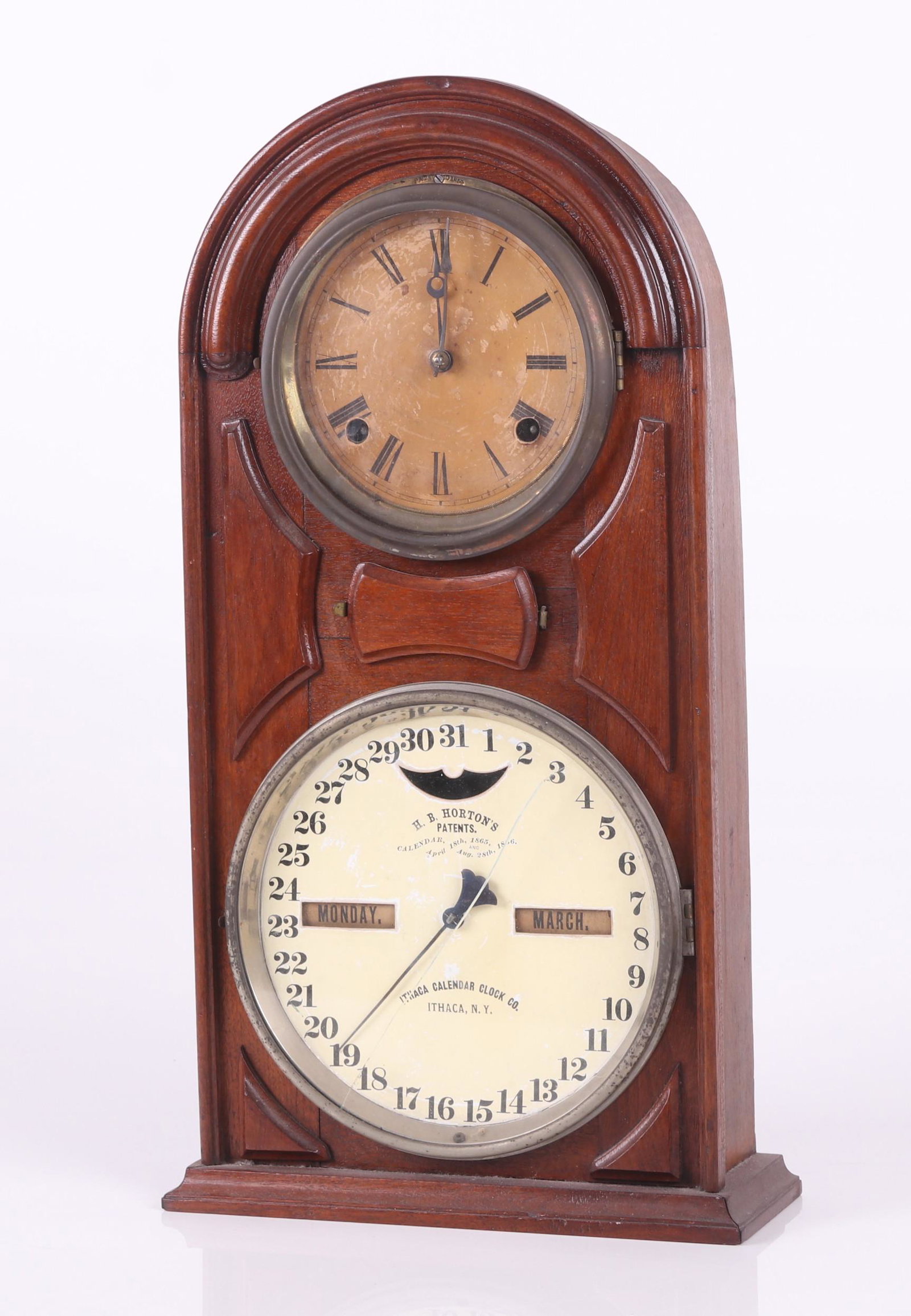 Shelf Calendar Clock, Ithaca Co.: Circa 1870, model number 5, round top, walnut case, double paper covered tin dials, the time dial with Roman numerals, eight day movement, chiming, labeled as pictured, and part of the original labels