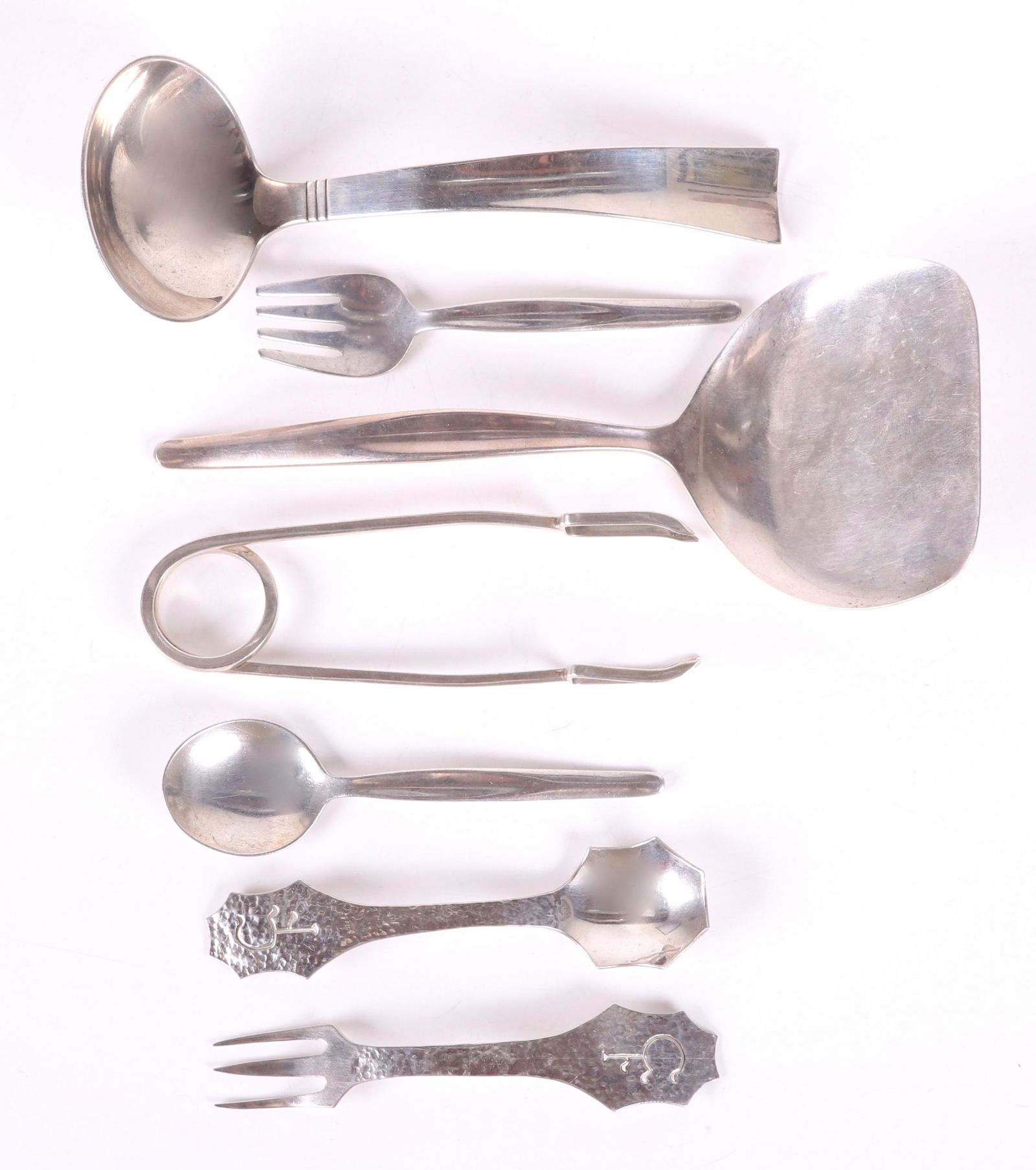 Group of Mid Century Modern Sterling Silver Flatware: Comprising: a 6" ladle, "Sunset" by Allan Adler; 5" ice tongs by Leonore Doskow; a 7 1/2" spatula, and a youth set including 4 3/8" spoon and fork, "Contour" by Towle; a hand hammered youth set includ