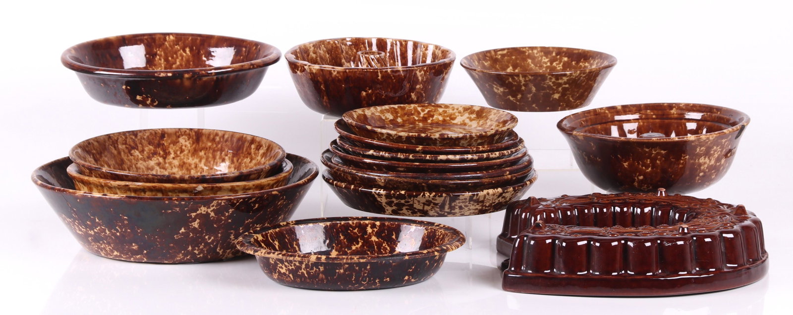 Rockingham Glazed Pottery Cake Molds, Kitchenware: Two bundt cake molds; a low relief tulip decorated horseshoe cake mold marked "959-29" with handle for hanging; four mixing bowls of various sizes; two oval bakers; and seven plates of various sizes, 