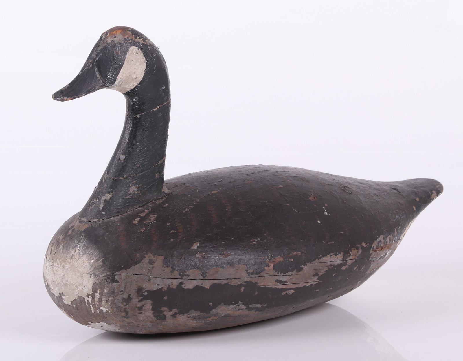 An Antique Canada Goose Decoy: Made in two parts, retains the original painted surface. Dimensions: 22" long, 12" wide, 13 3/4" tall. Provenance: From a Main Line collection.