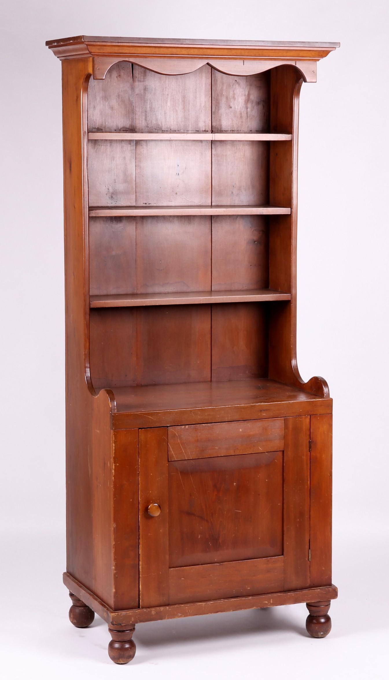 19th Century American Poplar Cupboard: A narrow cabinet with turned ball feet, a single paneled door, below three shelves and a molded cornice. Dimensions: The case is 31" at the waist, overall width of 36", 20" deep, total height of 80".