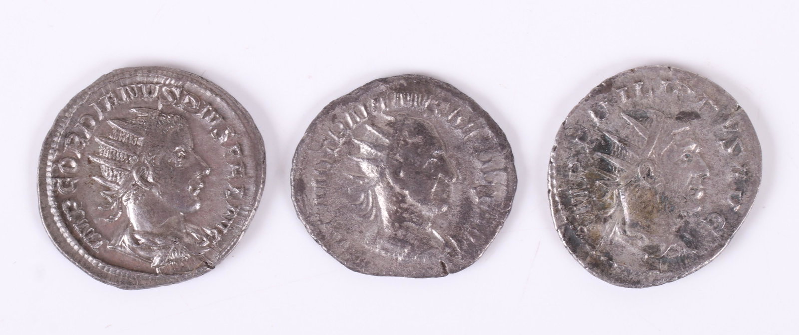 Three Ancient Roman Silver Antoninianus Coins: Philip I / cippus inscribed COS III; Gordian III / Apollo seated left with branch and lyre; Trajan Decius / Dacia standing left. Dimensions: Each is approximately 3/4" in diameter.