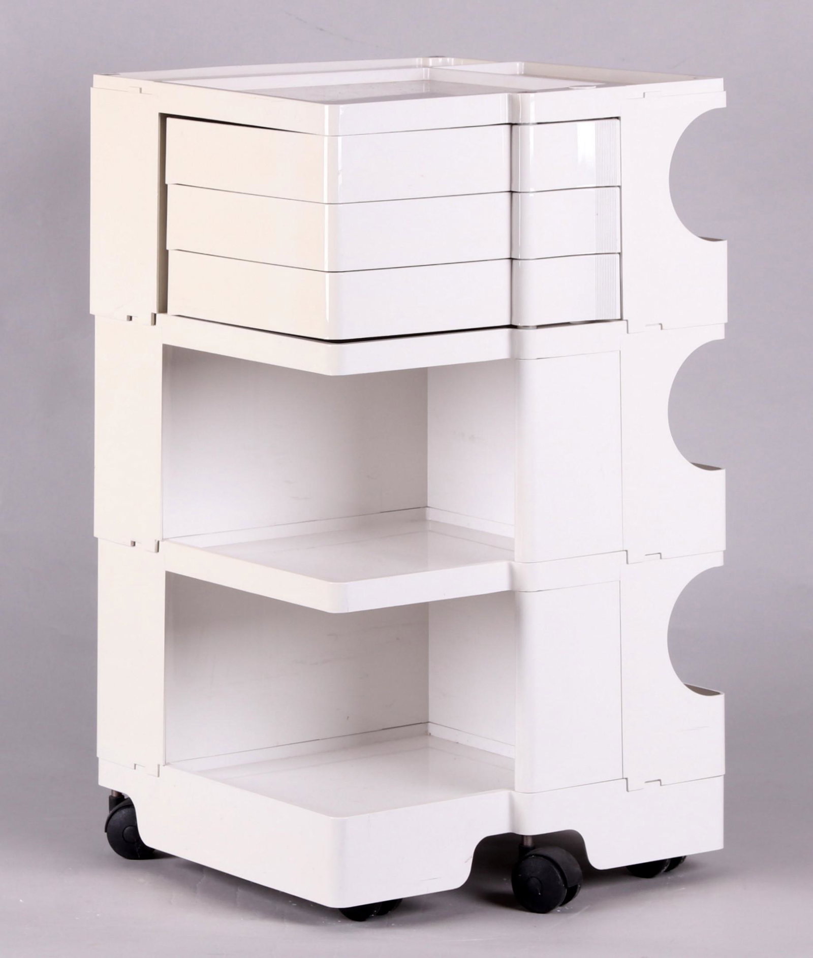 Boby Trolley by Joe Colombo for Bieffeplast: A white plastic storage trolley with casters, composed of three stacked units locked together, each with shelves, the top unit with three hinged drawers which can be moved to the other units, manufact