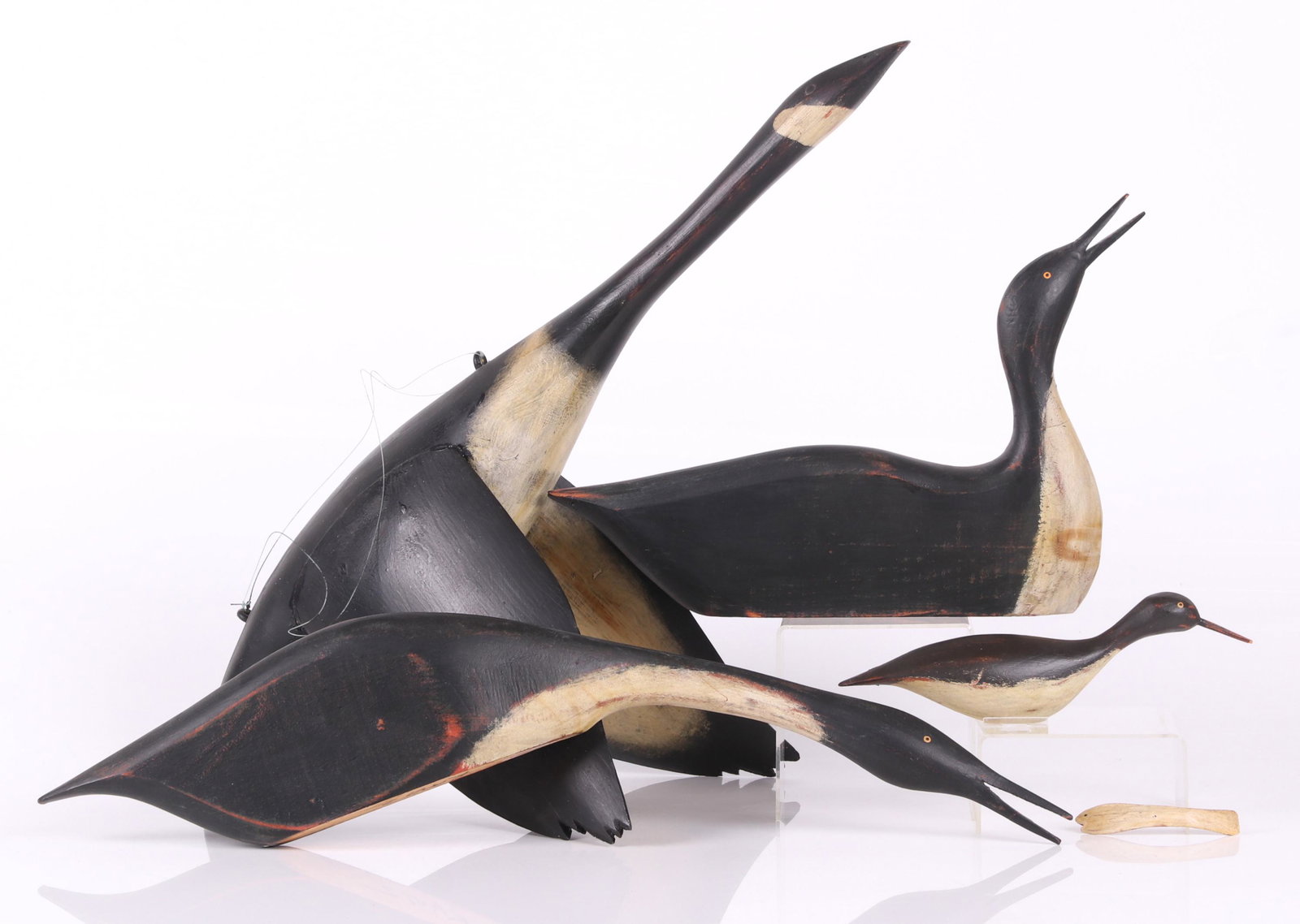 Three William Kautz Loons, Flying Canada Goose Decoy: A loon with it's head down below shelf level, a loon with it's head up and a detachable wooden fish which fits in the beak, and a baby loon, all signed Kautz on the foot; a 20th century flying Canada