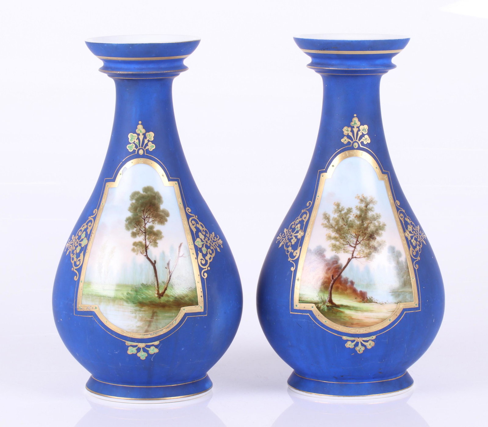 A Pair of Old Paris Porcelain Bottle Form Vases: Circa 1860, each pair form, with a matte blue ground and a landscape reserve, unsigned. Dimensions: Each is 7 1/2" in diameter and 13" tall. Provenance: From a Philadelphia estate.