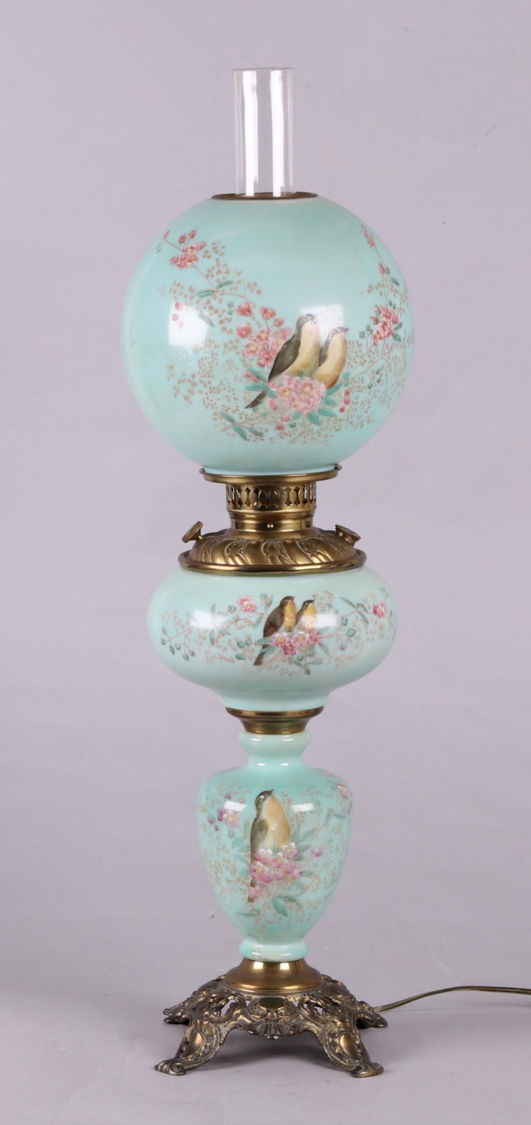 Gone with the Wind Parlor Lamp: Circa 1900. Turquoise glass column, font, and shade with enameled bird, floral, and foliate decoration, and brass mountings with decoration including scrolls, acanthus leaves, and shells. Dimensions: