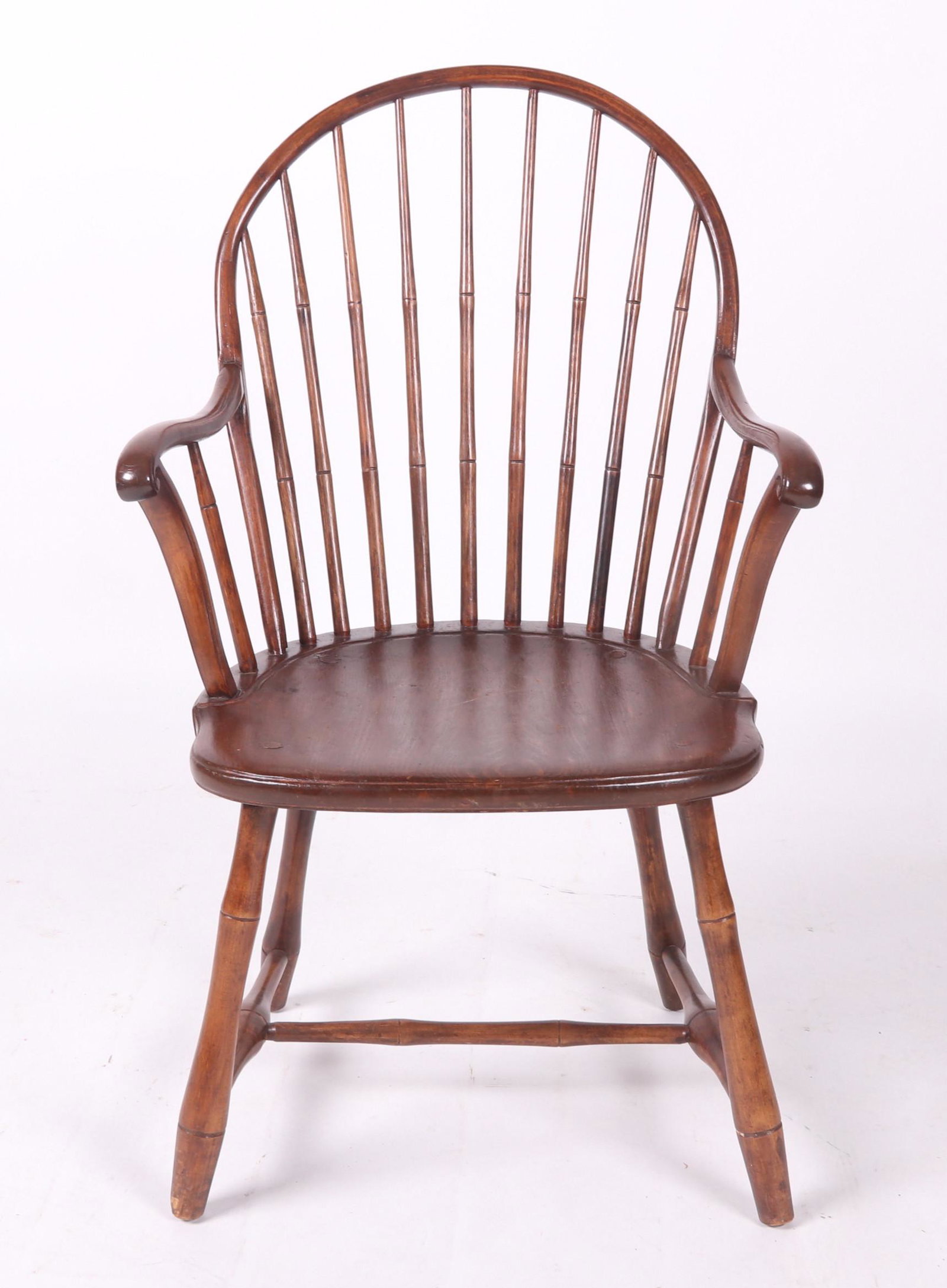 American Windsor Armchair, Circa 1800: With Bamboo turned legs. H form stretchers, plank seat, a 9 spindle bow back and serpentine arms. Dimensions: 22 1/4" arm to arm. 17" deep. Seat height is 16 1/2". Overall height is 36". Provenance: F