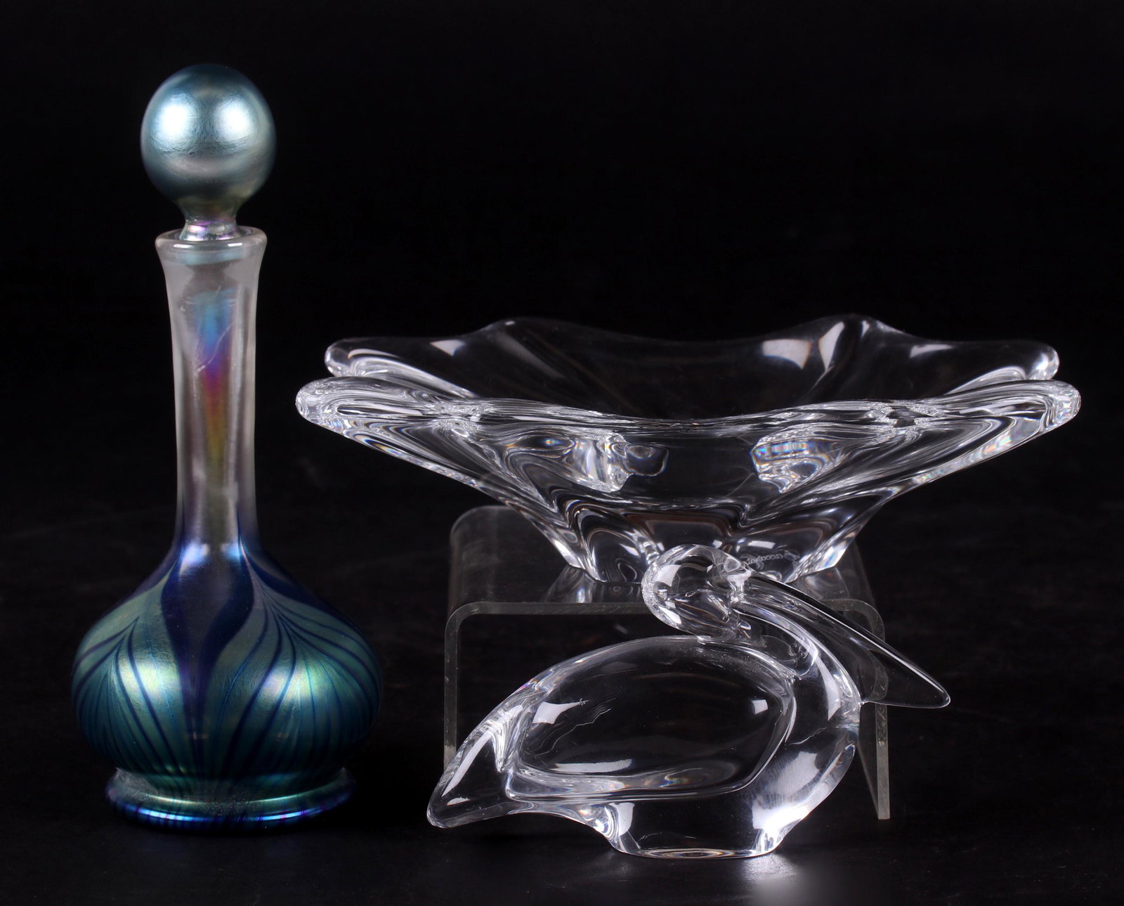 Three Pieces of Art Glass, Baccarat and Lundberg: Two piece of Baccarat, a "Cadix" dish and a pelican figure, both marked, the pelican also retains the original paper label, and a Lundberg scent bottle with iridescent blue, green, and yellow pulled f