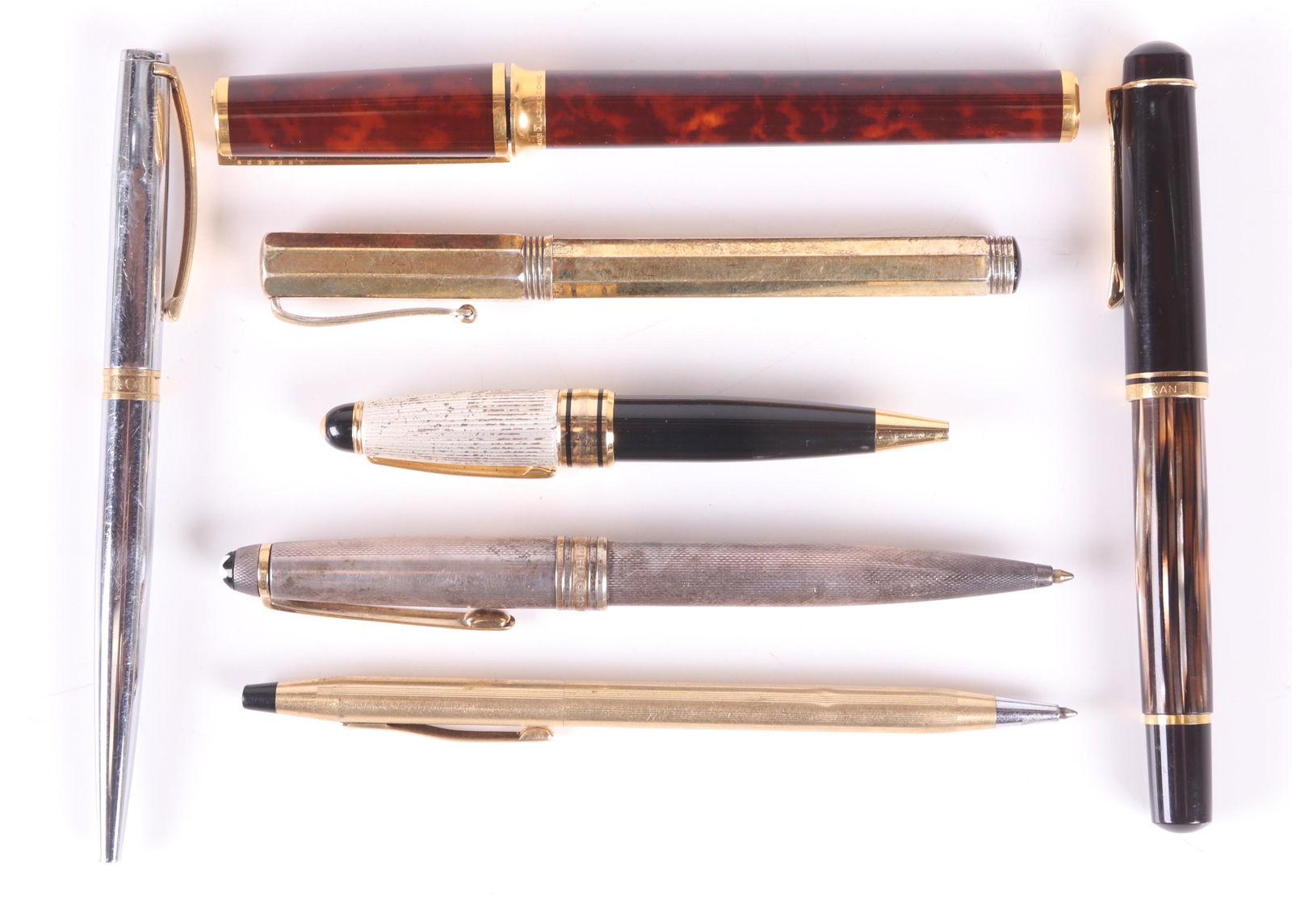 A Group of Vintage Pens, Dupont, Montegrappa: Comprising: a gold plated Montegrappa octagonal fountain pen, a lacquer and gold tone example by Dupont, an unmarked short ballpoint pen, a silver tone and gold tone ballpoint pen marked "Tiffany and