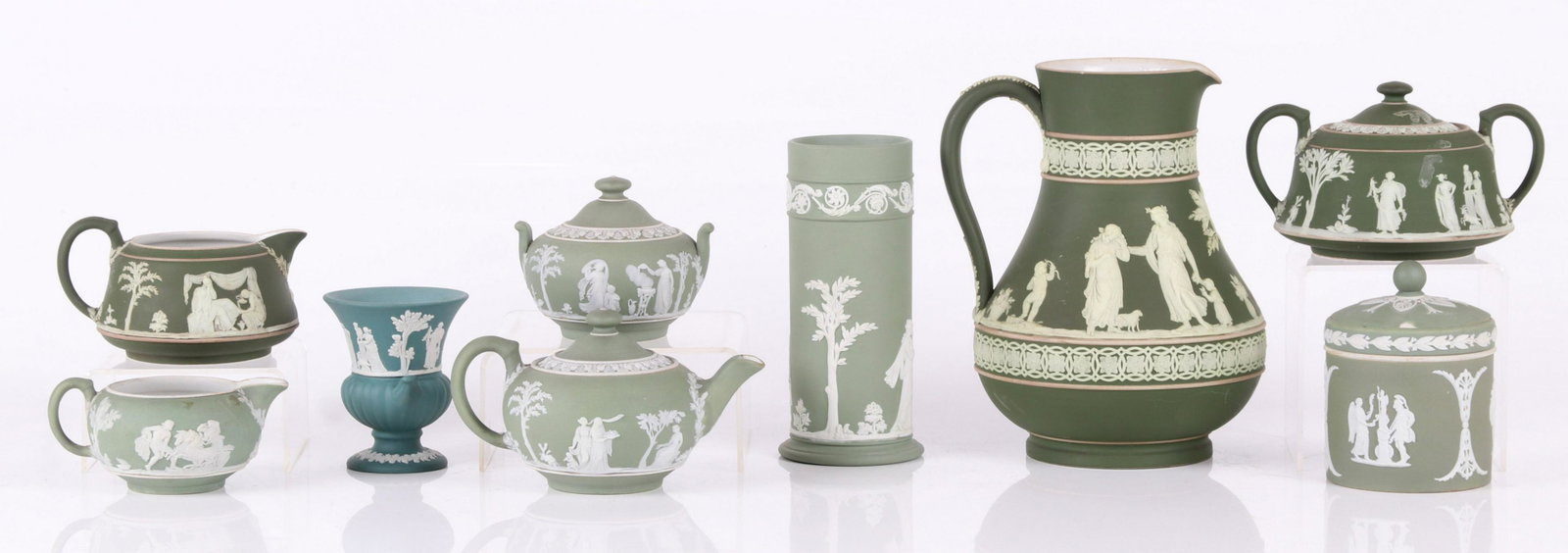 A Group of Green Wedgwood Jasperware: Comprising: a large jasper dip ewer, a solid green vase, a solid teal cigarette holder, an unusual jar with removable ring in green jasper dip, two creamers, two sugars and a small teapot. Dimensions: