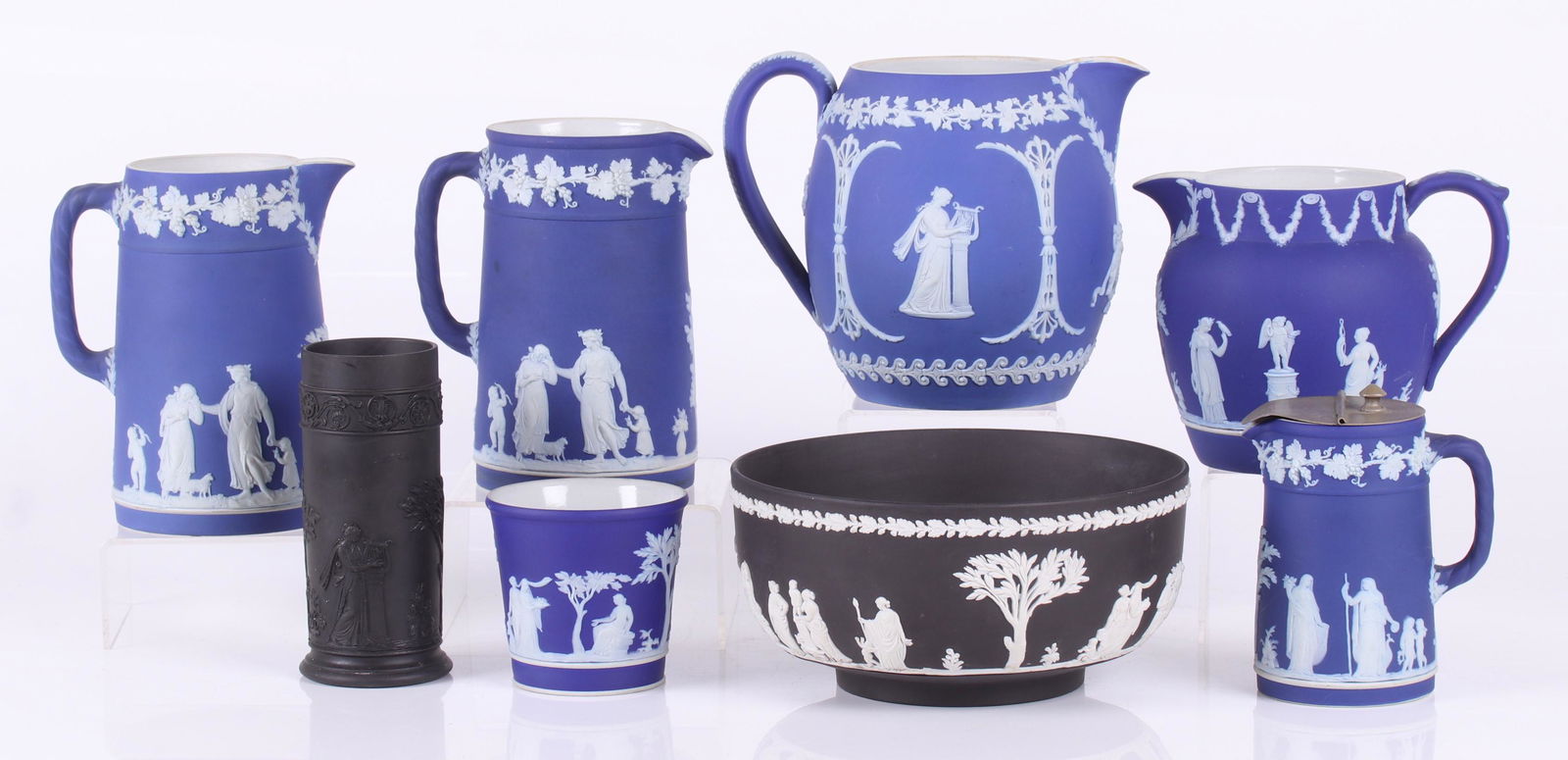A Group of Wedgwood Jasperware, Dark Blue, Black: Comprising: five dark blue jasper dip pitchers, one with silver plated lid, a small dark blue planter, a black basalt bud vase and a solid black jasperware bowl. Dimensions: From 2 1/4" to 7 1/2" in d