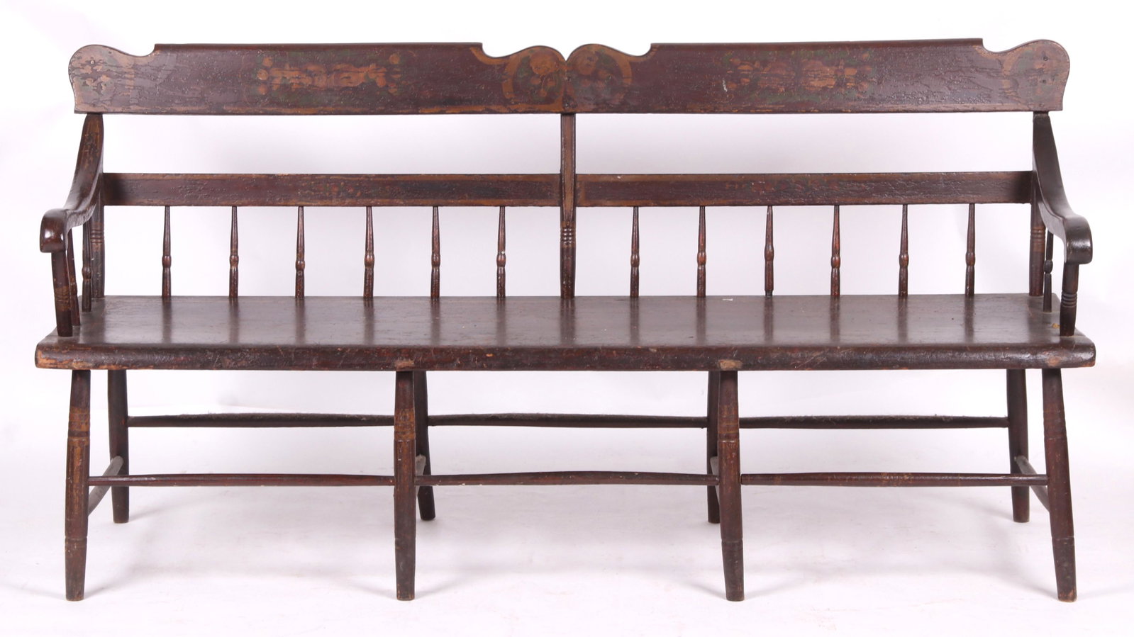 A Painted Decorated Windsor Settee: From the first half of the 19th century, with a plank seat and a back with half spindles and a scrolled crest rail. Dimensions: 69" long, 19 1/2" deep and the seat height is 17 1/2".