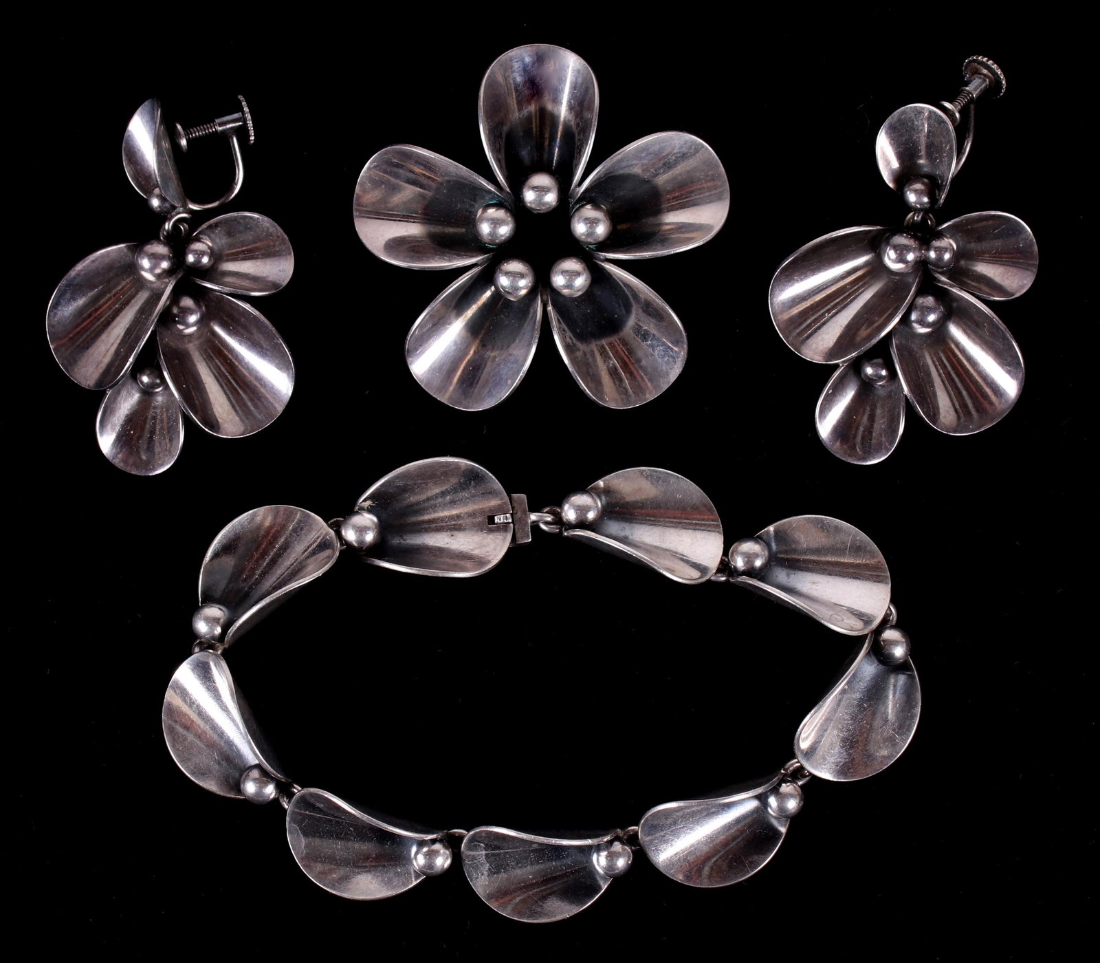 A Set of Danish Sterling Jewelry by N.E. From: A bracelet, pair of earrings and brooch, all blossom form, all signed as pictured. Dimensions:The bracelet is 7 1/2" long, the earrings are 2" long and the brooch has a diameter of 1 3/4". The total a